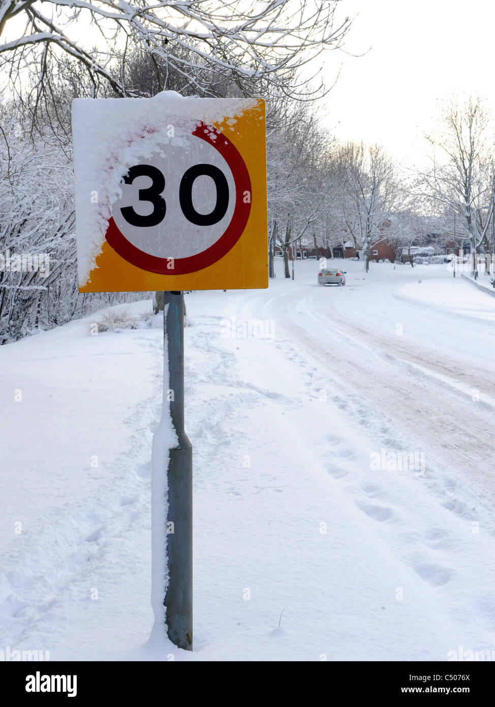 Una señal de límite de velocidad cubierto de nieve. Foto de stock