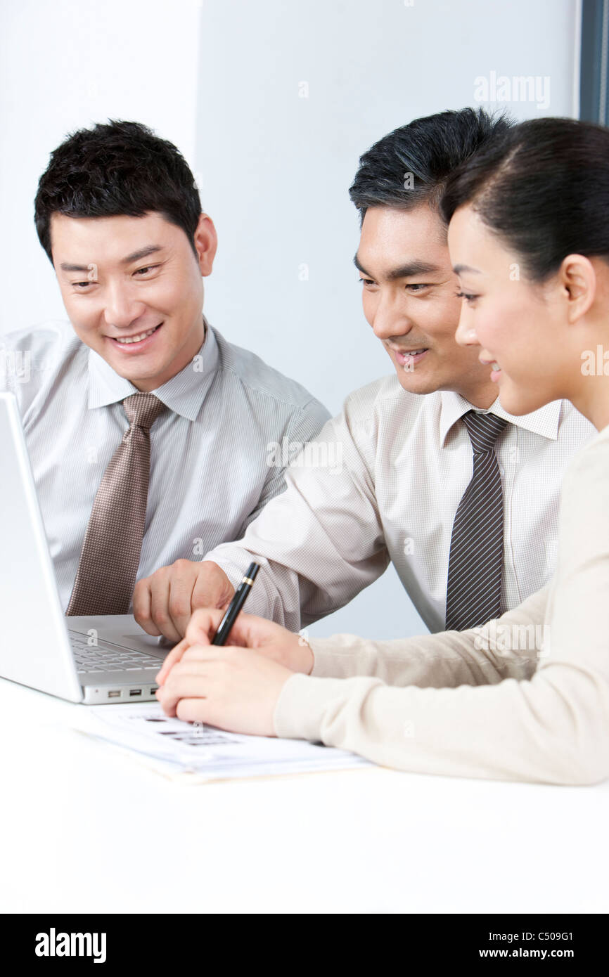 Ejecutivos de negocios, mostrando los jóvenes empresarios algo en el equipo Foto de stock