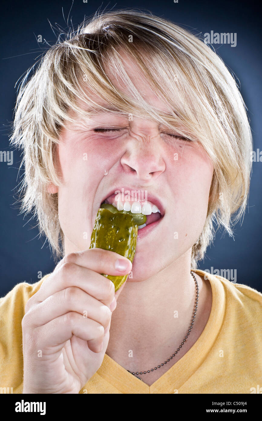 Muchacho caucásico comer pickles. Foto de stock