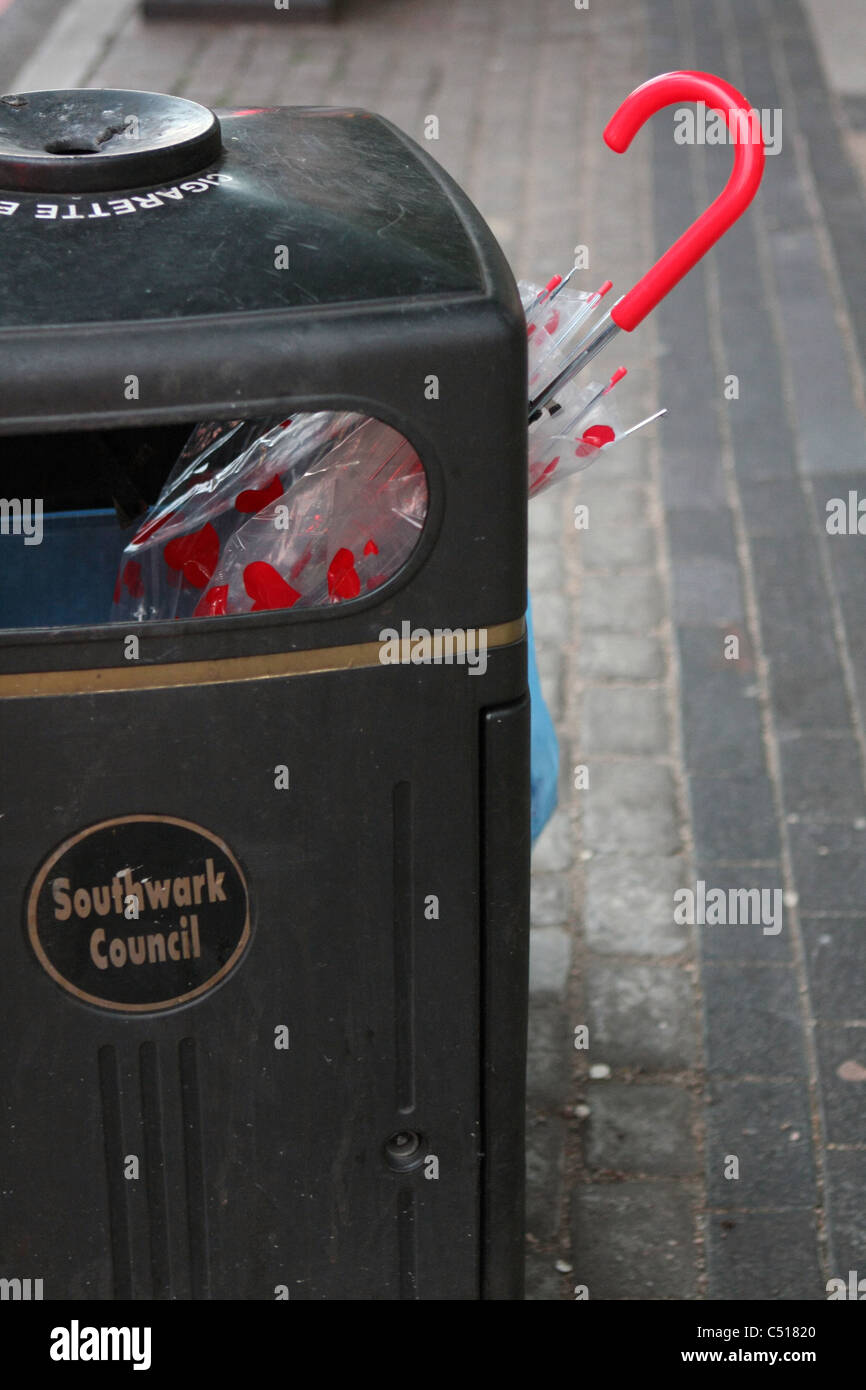 Un paraguas que sobresale de un cubo de basura en una calle de Londres  Fotografía de stock - Alamy