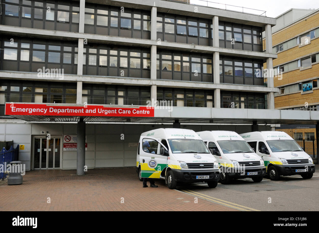 Departamento de emergencia y centros de atención de urgencia, con tres ambulancias estacionado frente Whittington Hospital Highgate Hill arco Foto de stock