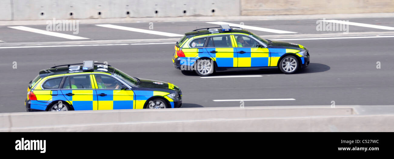 Dos coches de policía policía de Essex viajar a velocidad circulando por la autopista M25 oficial conductor llevaba chaqueta de alta visibilidad Inglaterra Foto de stock