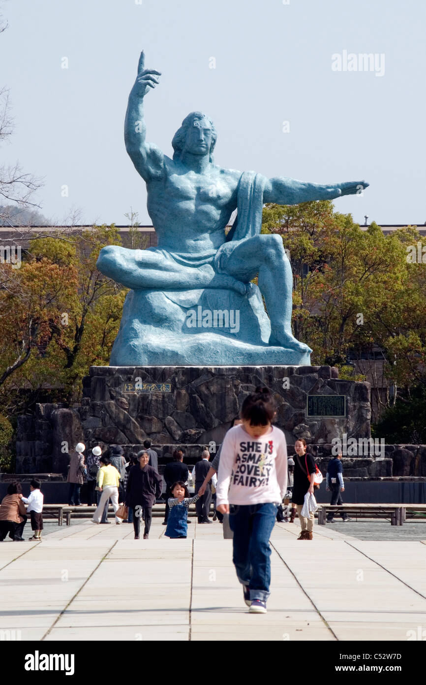 Niña caminando delante de la Estatua de Paz de Nagasaki, el Parque de la paz, Urakami, Nagasaki, Japón. Foto de stock