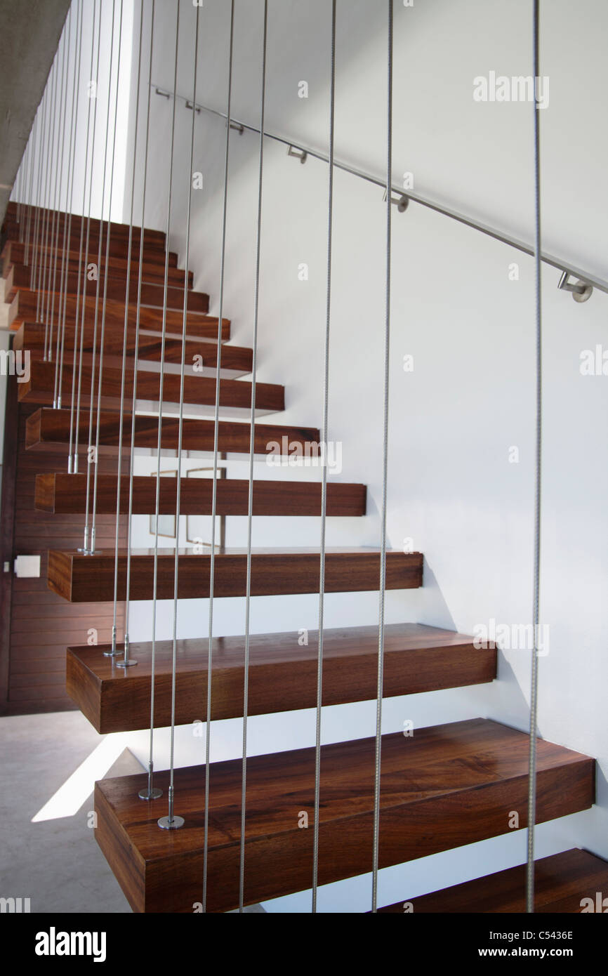 Escalera de madera con paredes blancas y baranda metálica Fotografía de  stock - Alamy