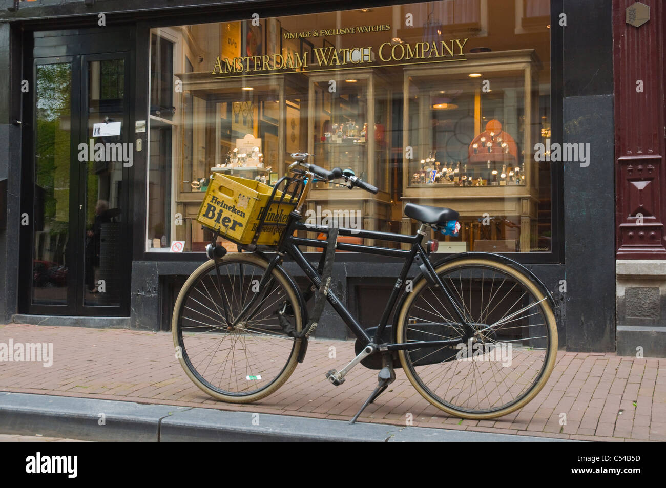 Bicicleta estacionado en la parte frontal del relojero de la tienda central de Amsterdam Países Bajos Europa Foto de stock