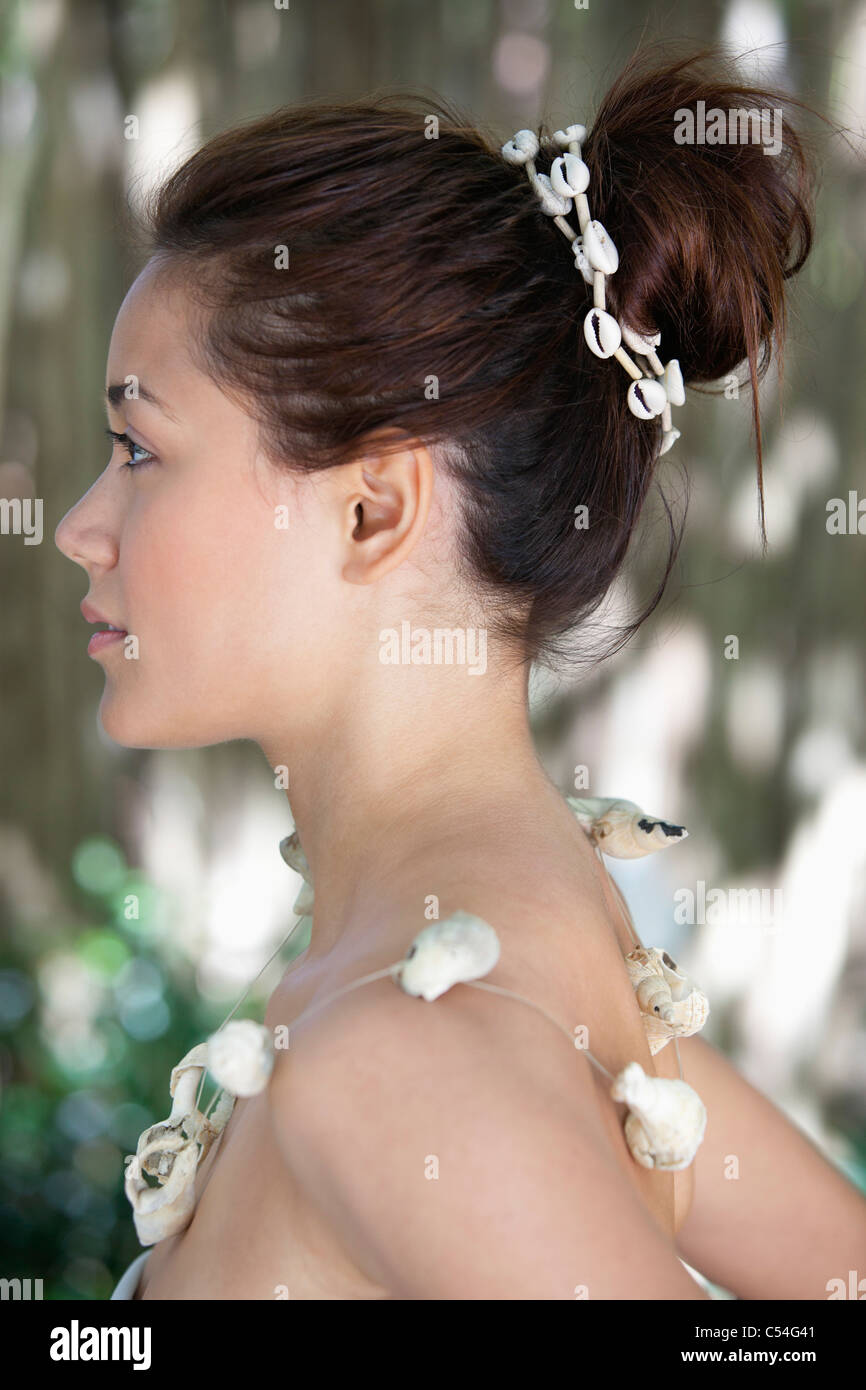 El perfil lateral de una joven y bella mujer vistiendo un collar de shell Foto de stock