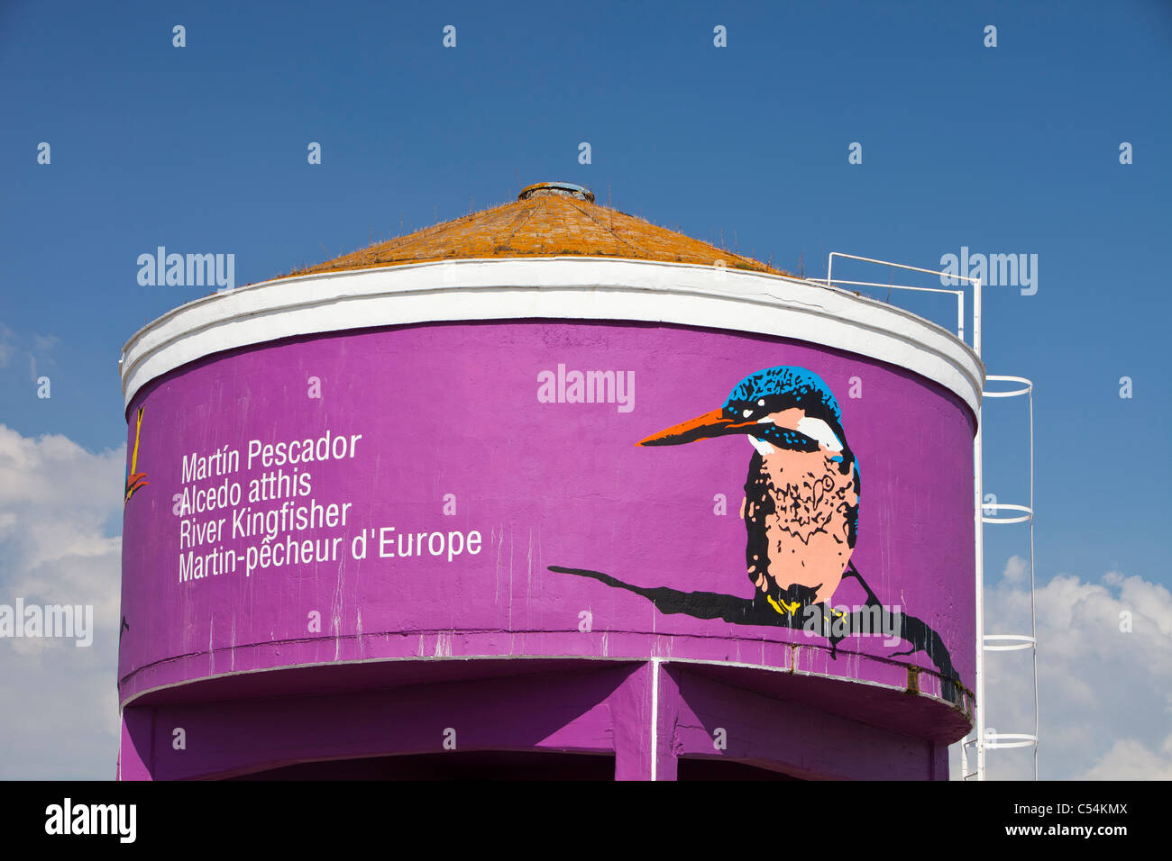 Un tanque de almacenamiento de agua pintada con un martín pescador para mostrar las áreas importantes para la vida silvestre en la Isla Mayor, una ciudad en el Coto Doñana Foto de stock