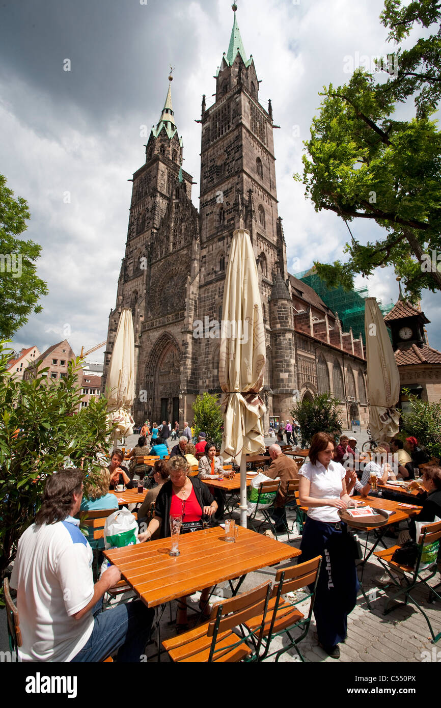 Gewitterwolken Menschen im Biergarten an der Lorenzkirche in der Altstadt gastronomía en el pueblo, la iglesia de St. Lorenz nubes Foto de stock