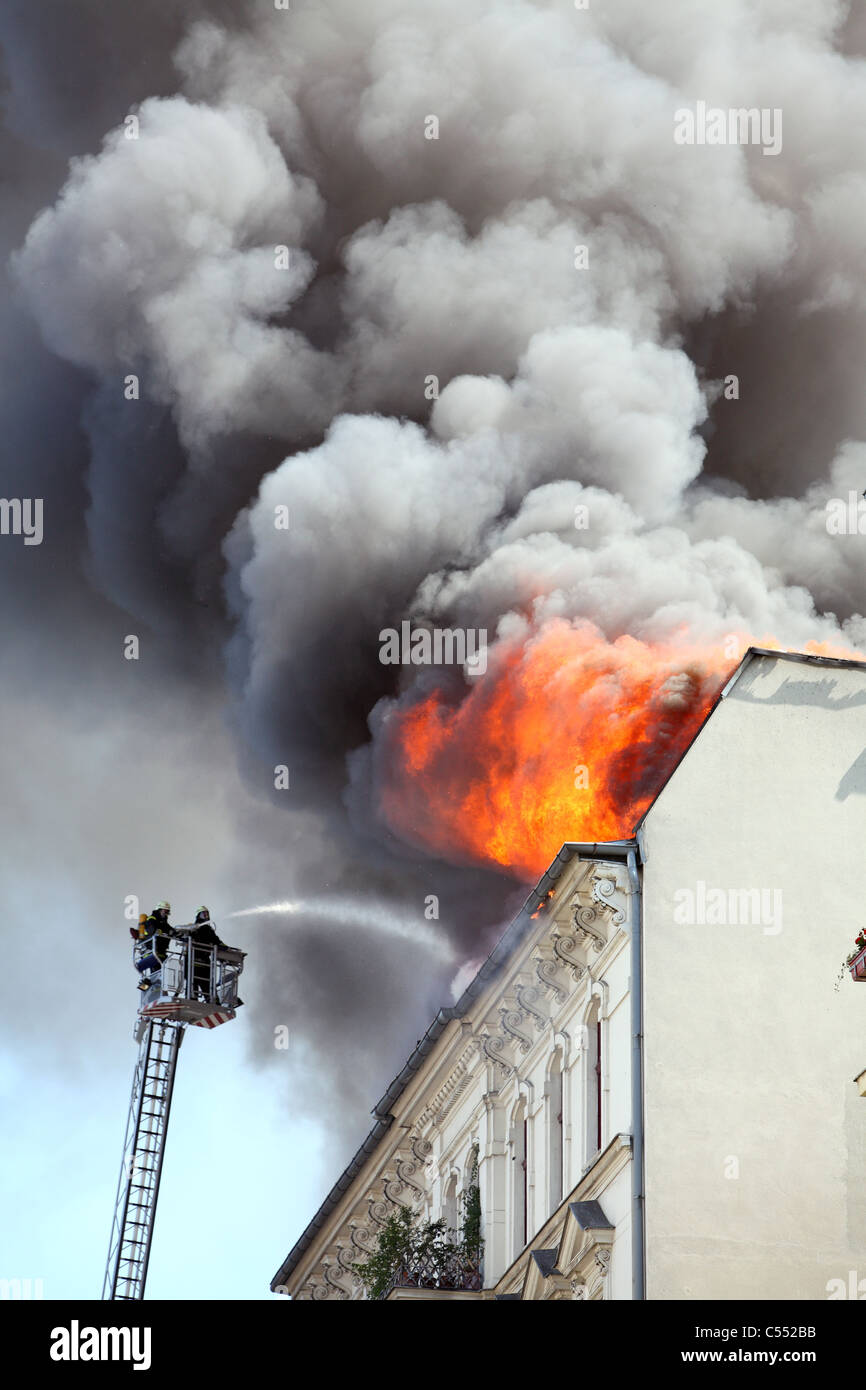 El vehículo recreativo atrapa fuego.los bomberos en la sombra rocían agua  Fotografía de stock - Alamy
