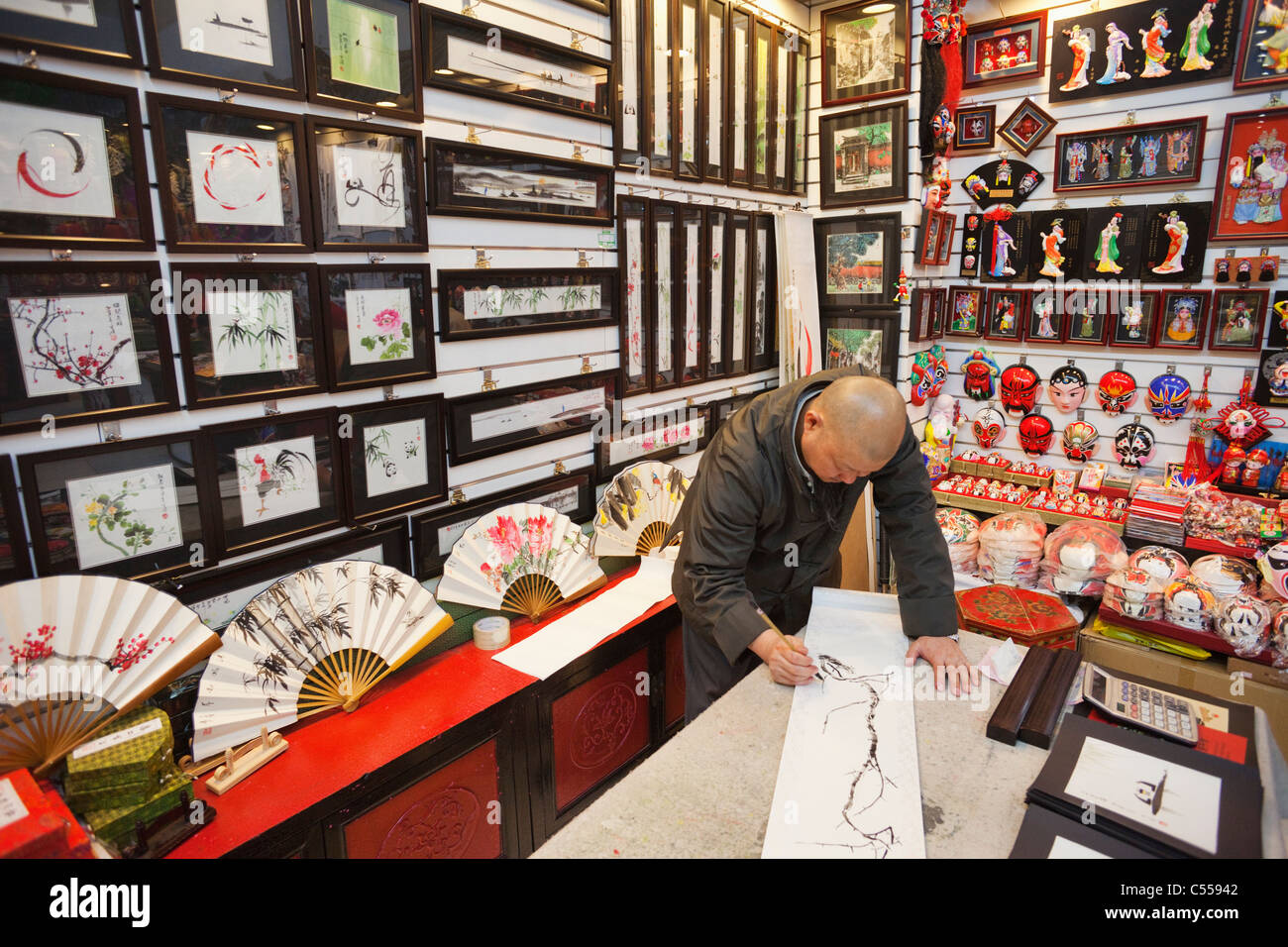 Pintando una ilustración tradicional en una tienda, en el mercado de la Seda, Beijing, China