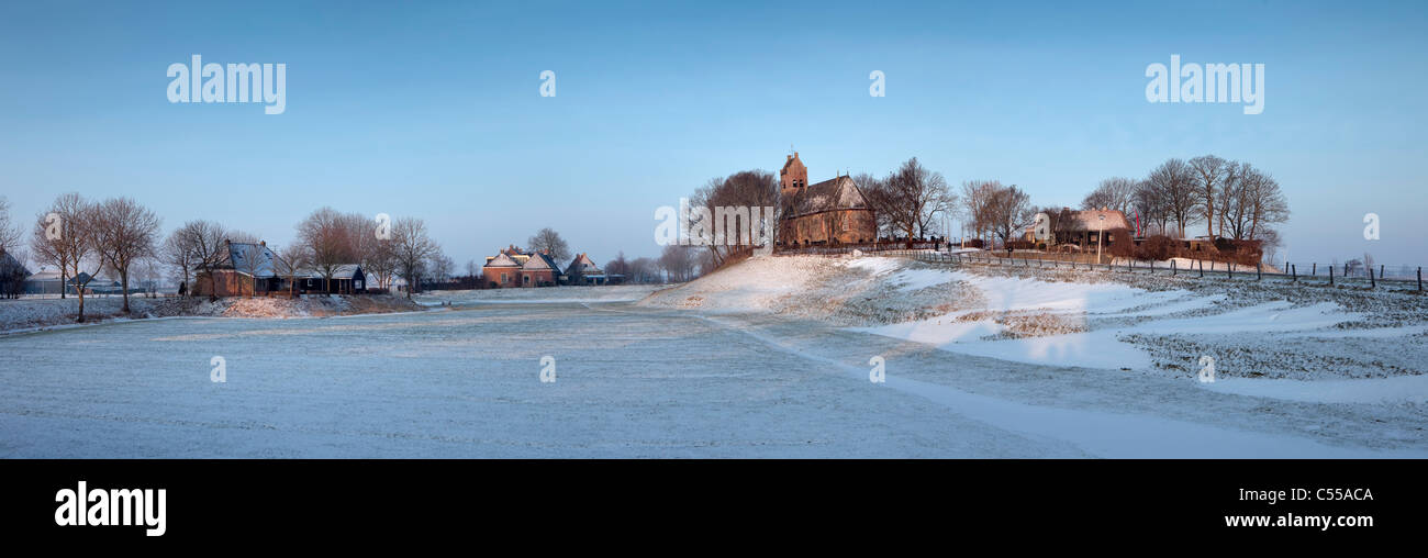 Los Países Bajos, Hogebeintum, vistas panorámicas de la iglesia sobre el montículo. La nieve. Foto de stock