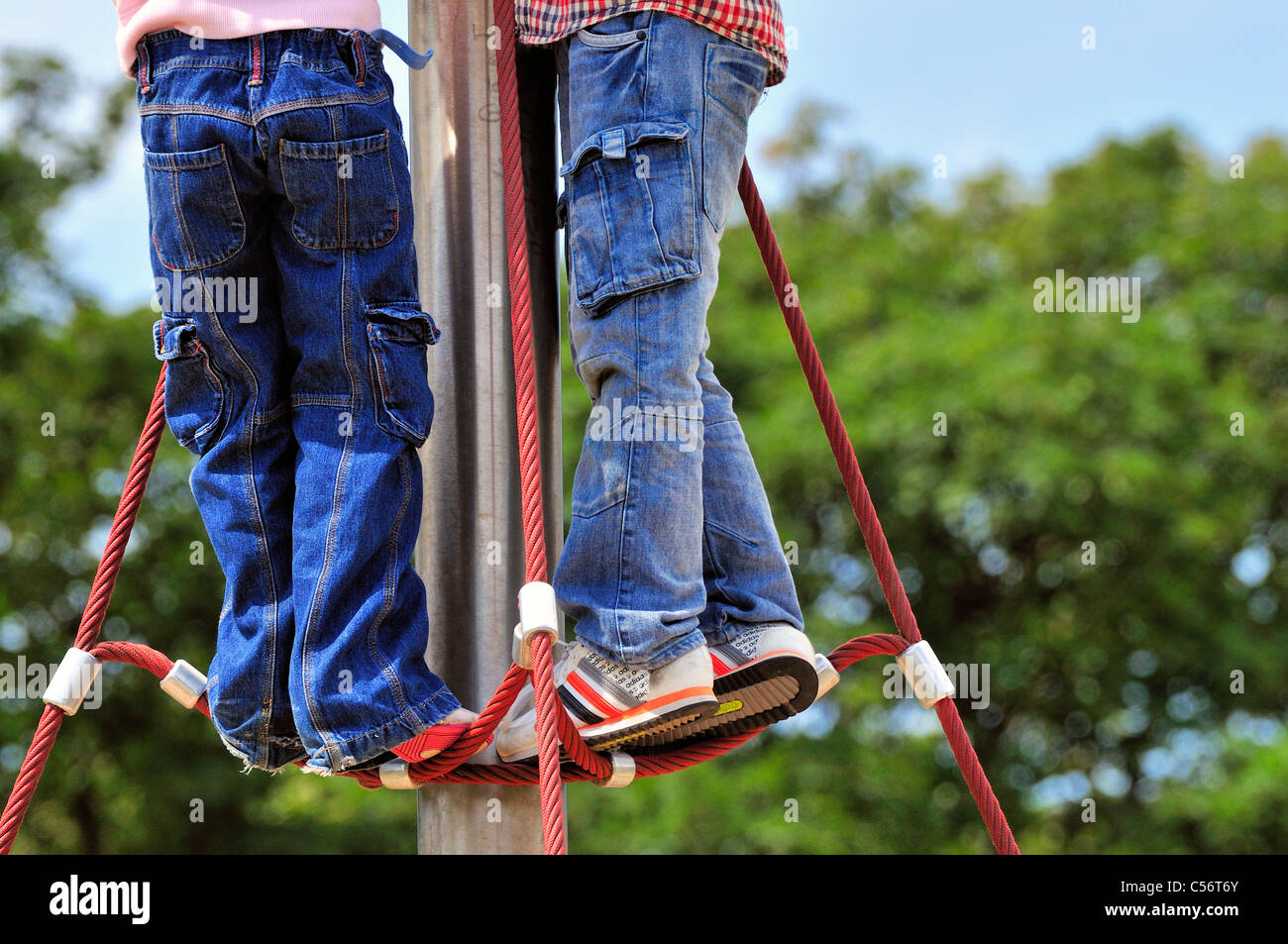 Dos niños top escalada pole,lleva vaqueros ,muchos bolsillos ,instructores  , cintura para abajo shot Fotografía de stock - Alamy