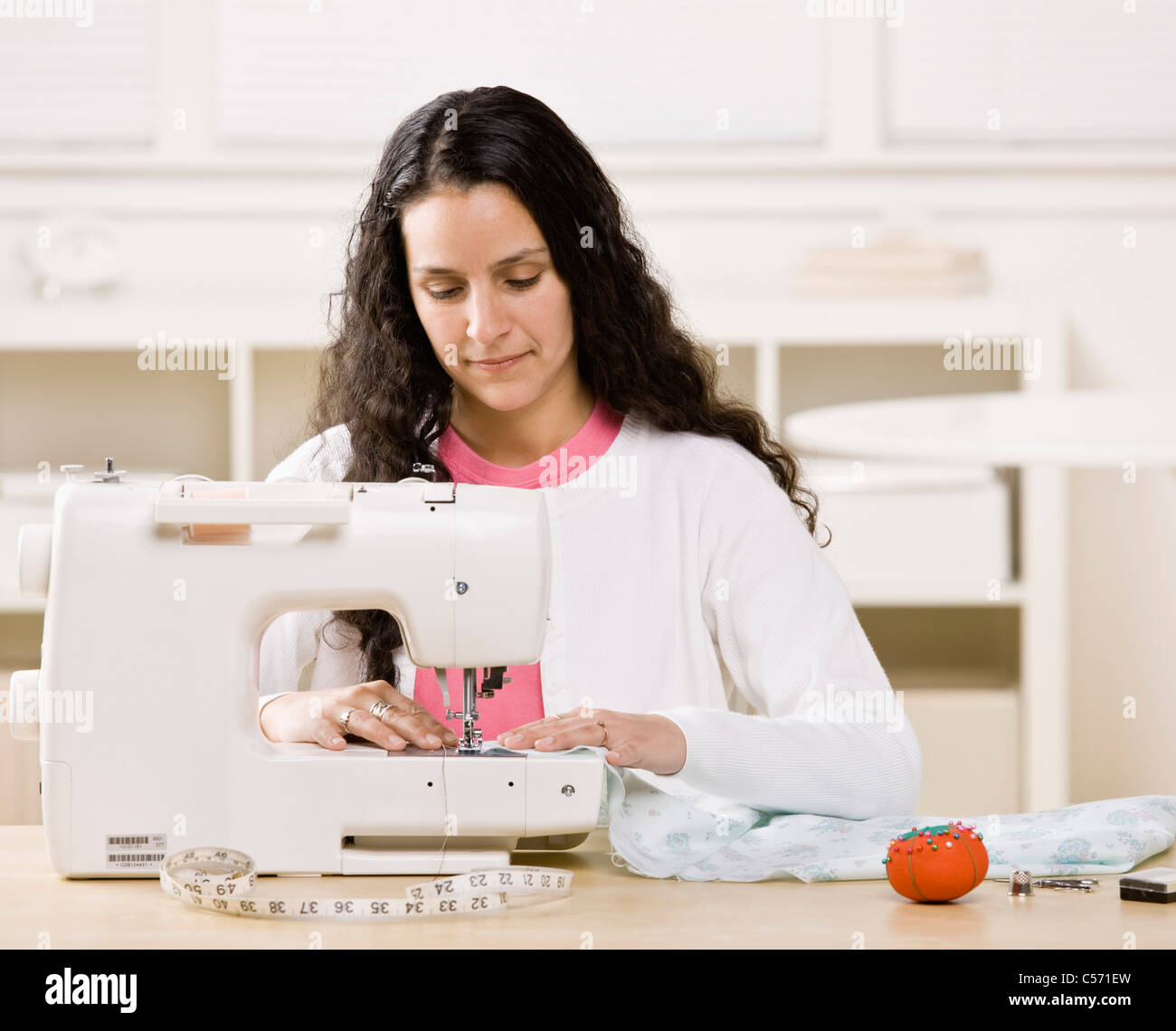 máquina de coser de color blanco. la costurera está en su oficina que está  con ropa diferente 15461656 Foto de stock en Vecteezy
