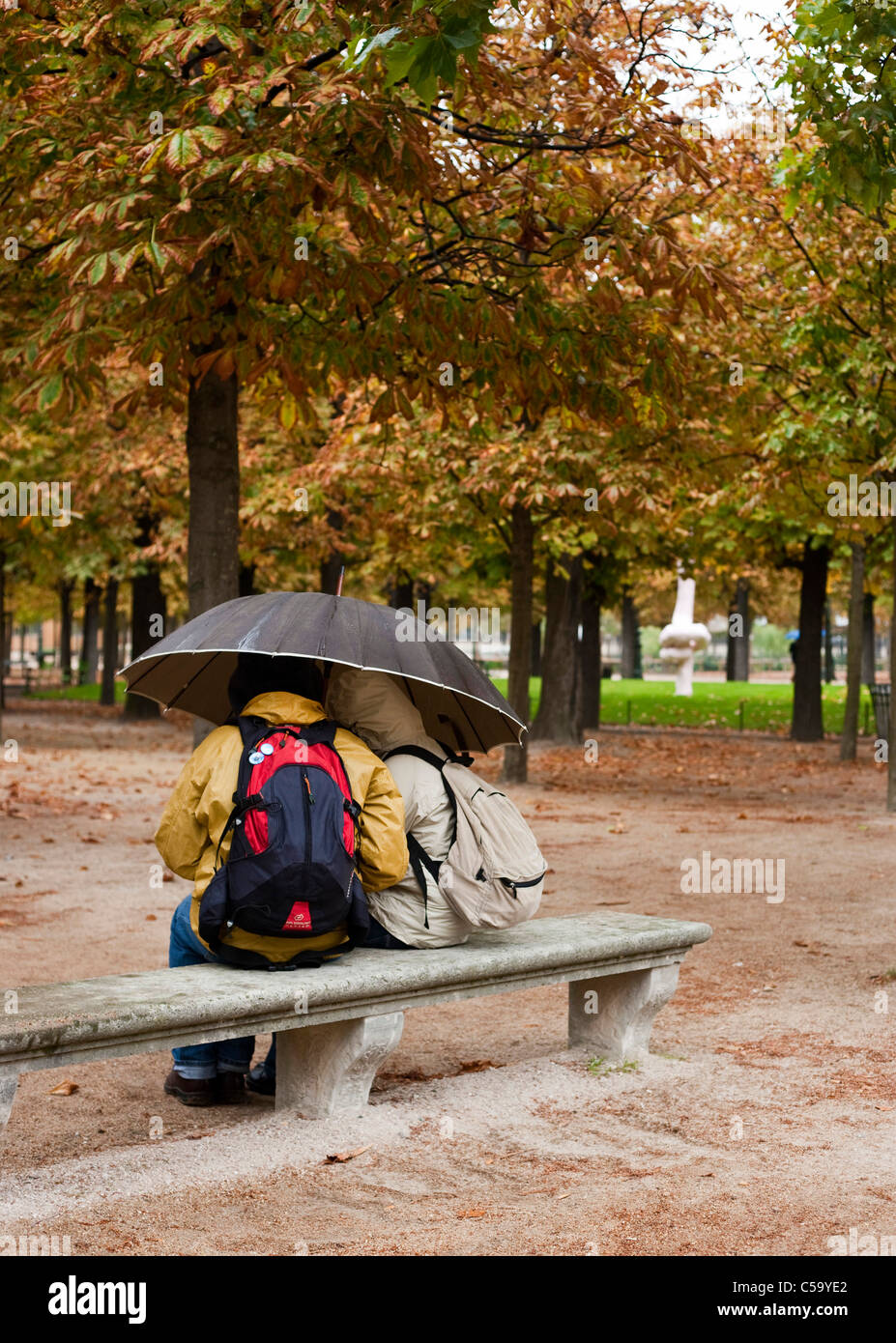 Un par de protegerse de la lluvia en el Jardin des Tuileries. París. Francia Foto de stock