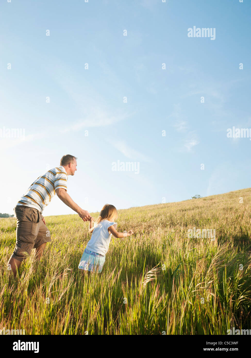 Padre e hija caminar cuesta arriba juntos Foto de stock