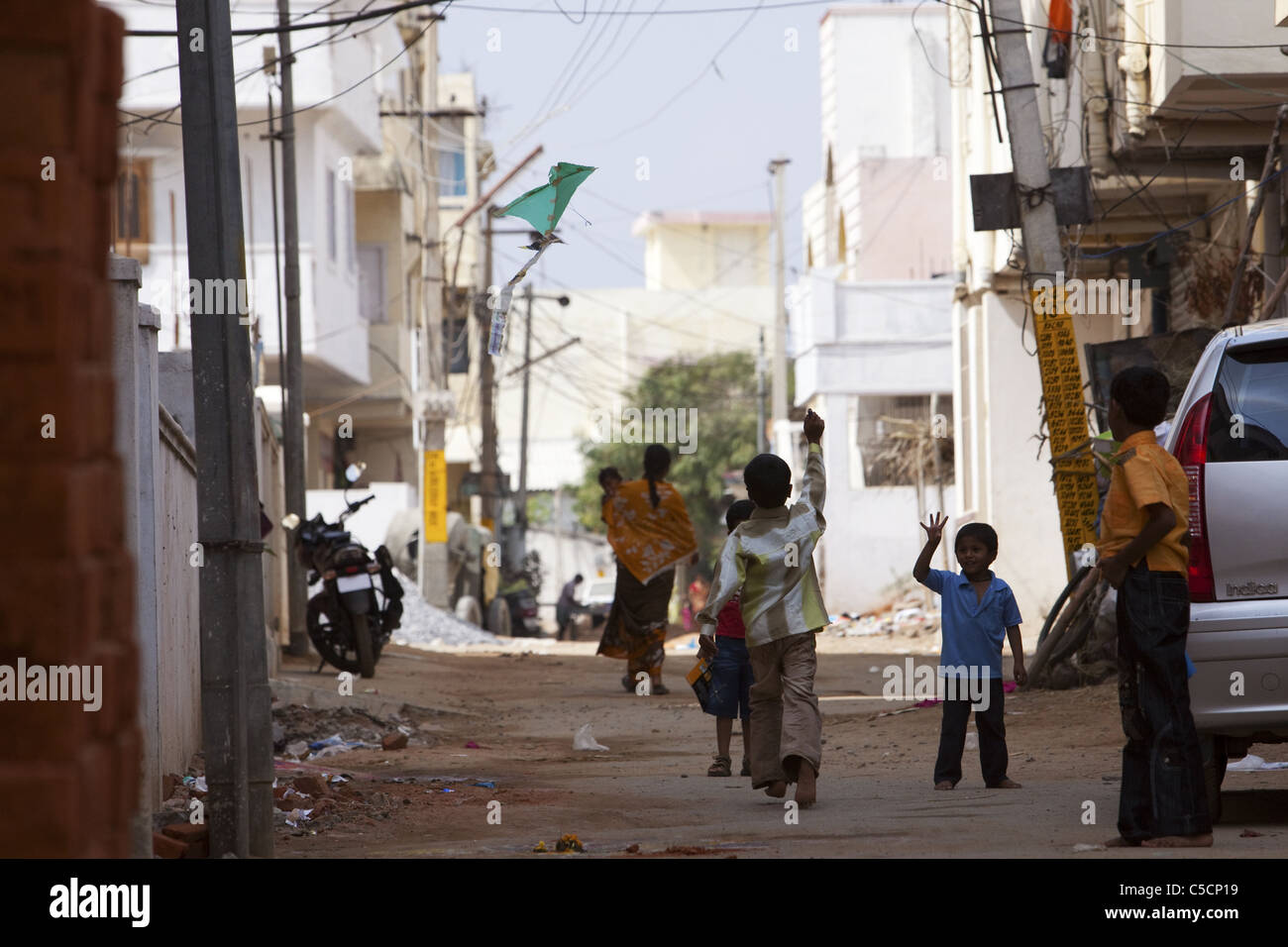 Los niños indios jugando con un papel de cometas en la calle Foto de stock