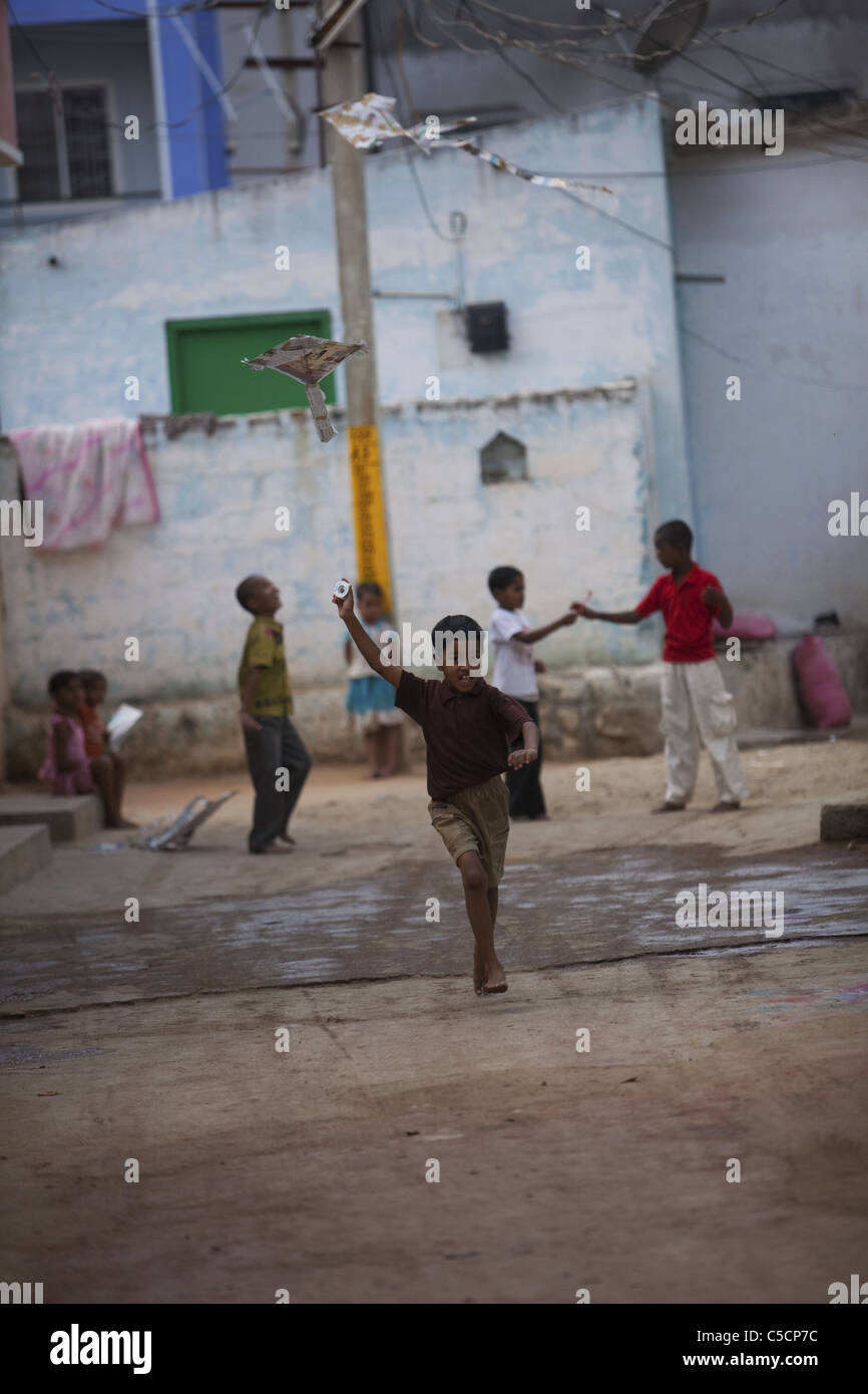 Los niños indios jugando con cometas de papel en calle Foto de stock