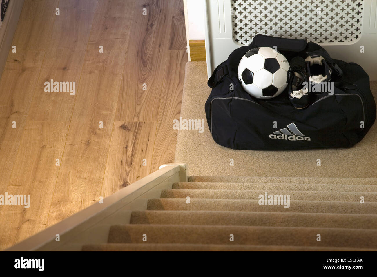 Bolso,bola de fútbol y botas de fútbol listo para tomar en la parte  inferior de la casa escaleras Fotografía de stock - Alamy