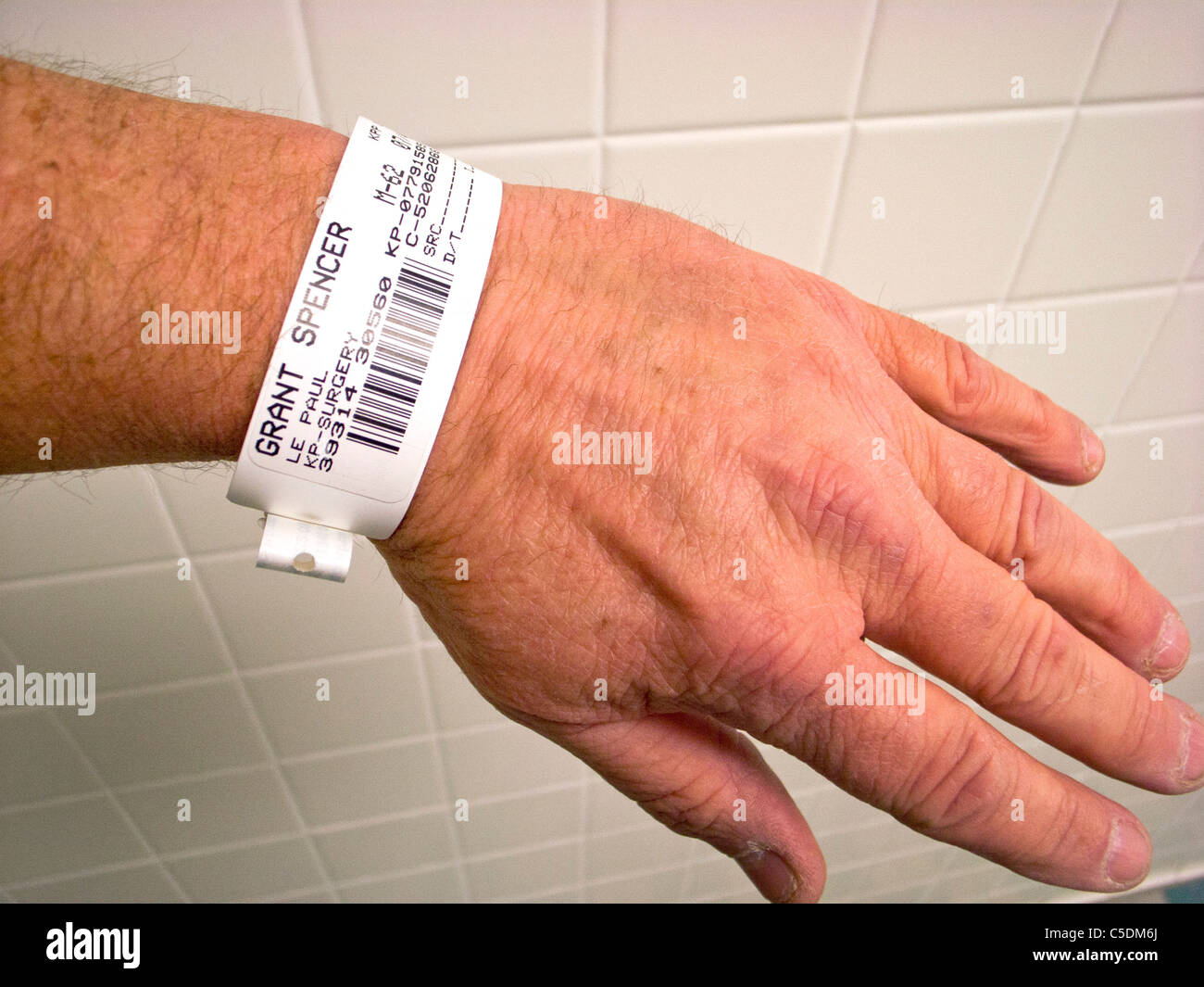 Un paciente del hospital lleva una pulsera de identificación con código de barras. Foto de stock