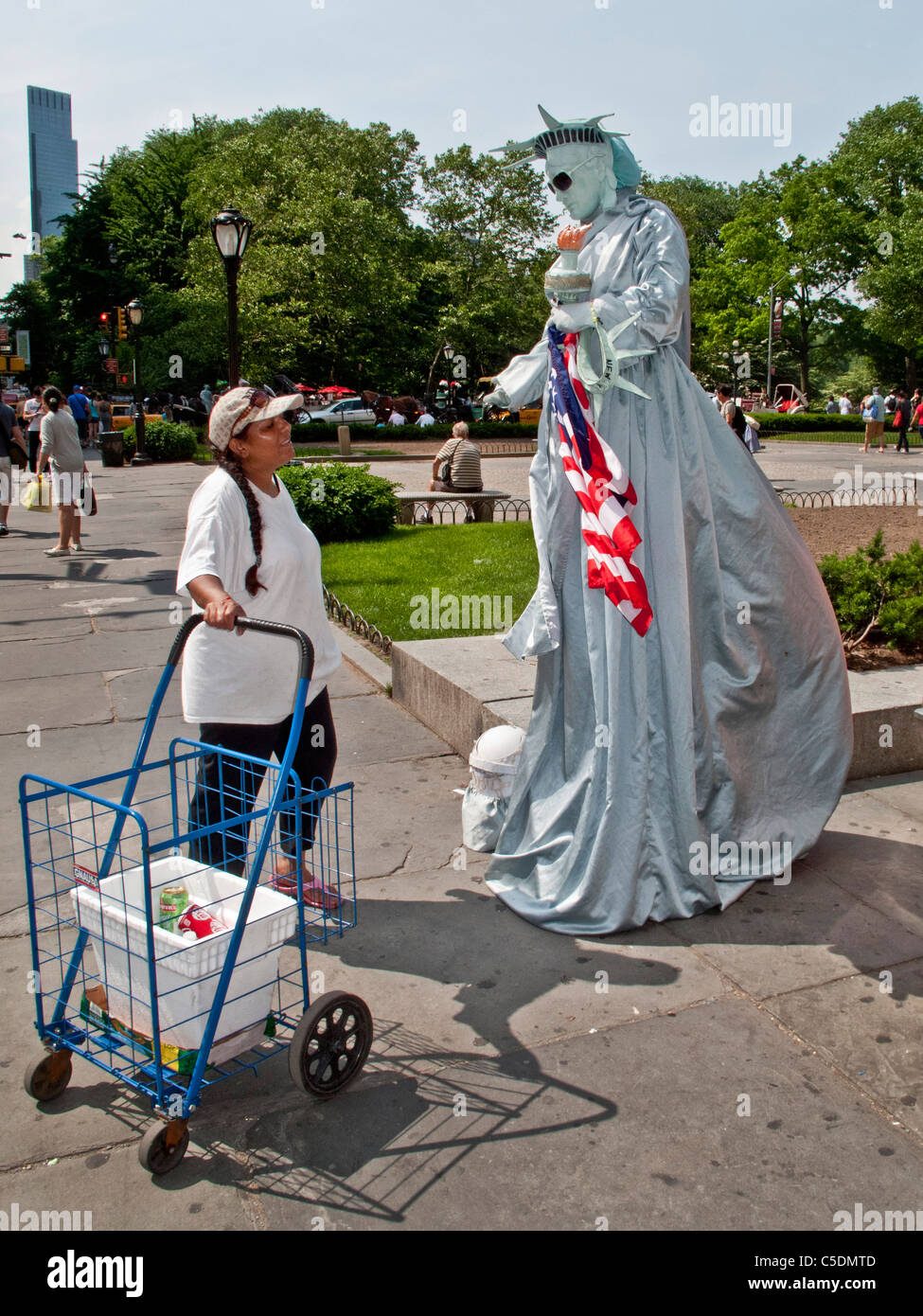 Un mimo vestido como la Estatua de la libertad las conversaciones con un transeúnte en la Quinta Avenida, Manhattan, Ciudad de Nueva York. Nota gafas de sol. Foto de stock