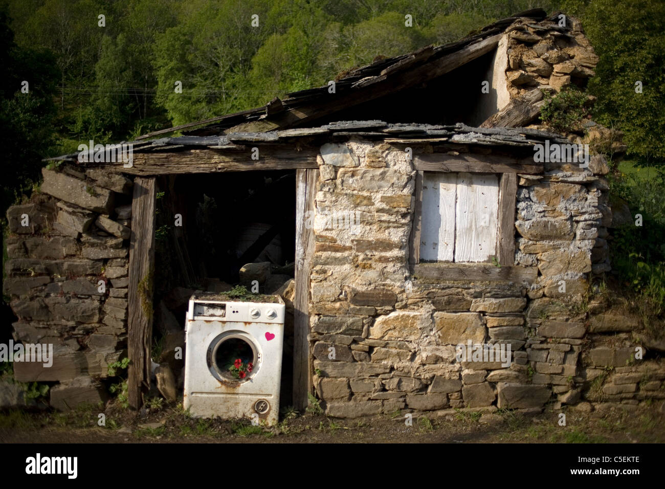 Una lavadora rota bloquea la puerta de una casa abandonada ubicada en el  Camino Francés del Camino de Santiago, en Galicia, España Fotografía de  stock - Alamy