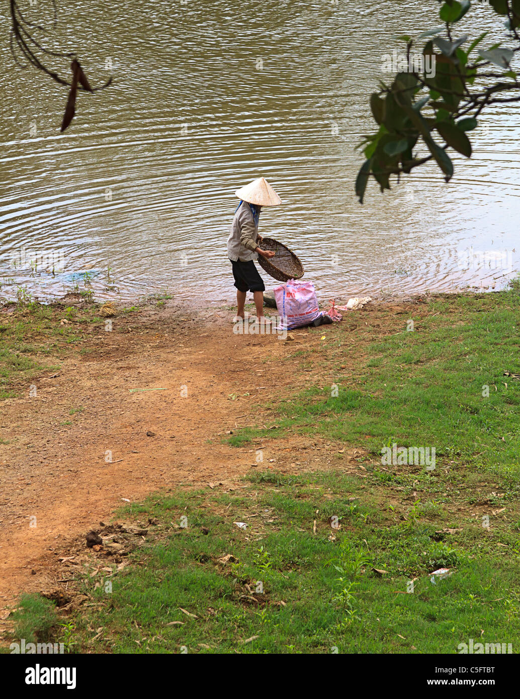 La mujer termina lavando ropa en el río en yenes Village, a 37 km al norte de Hanoi, en Vietnam del Norte. Foto de stock