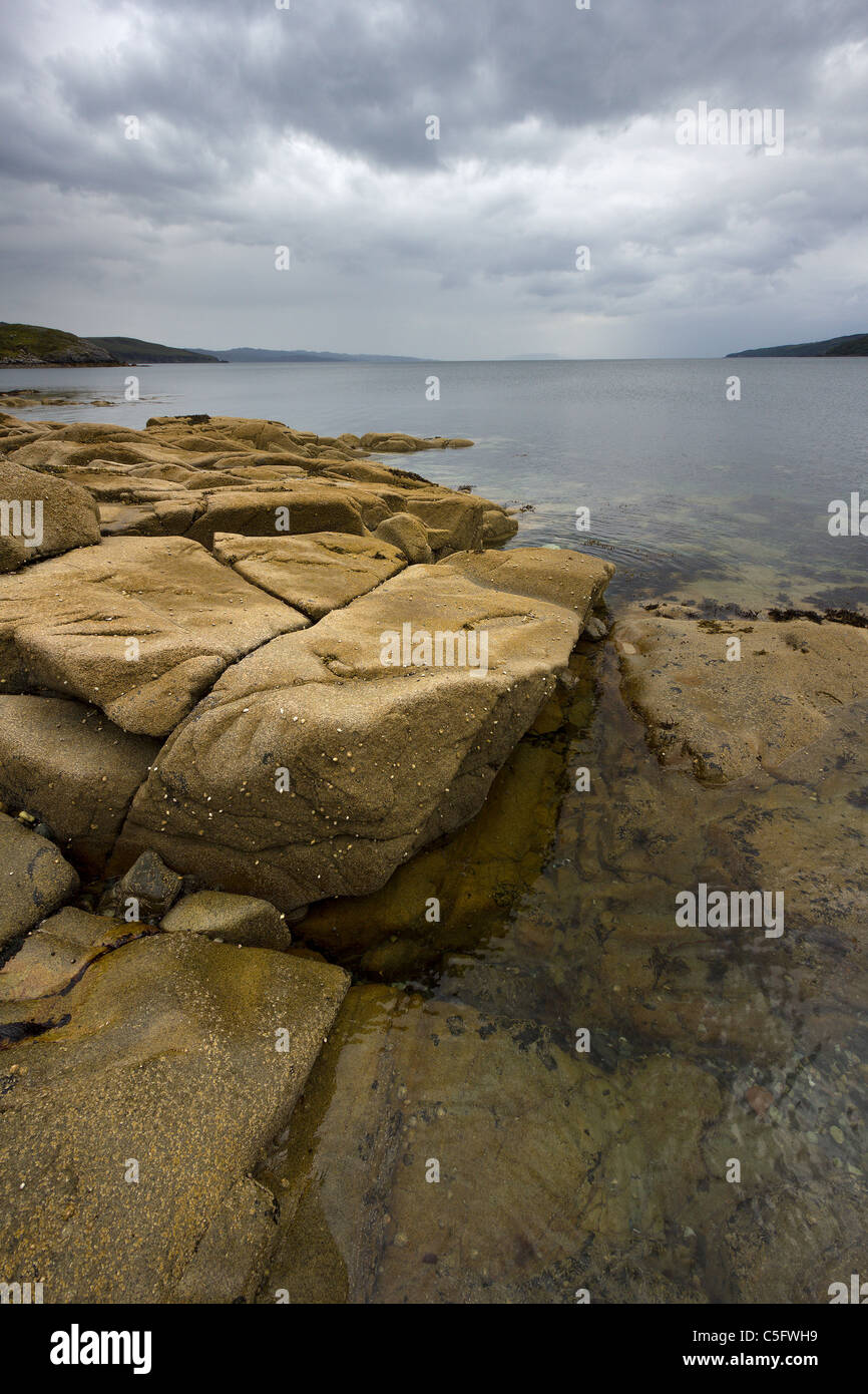 Costa rocosa, mar calma loch con nublado, amenazante cielo gris, Camas, Torrin Malag,la Isla de Skye, Escocia, Reino Unido Foto de stock