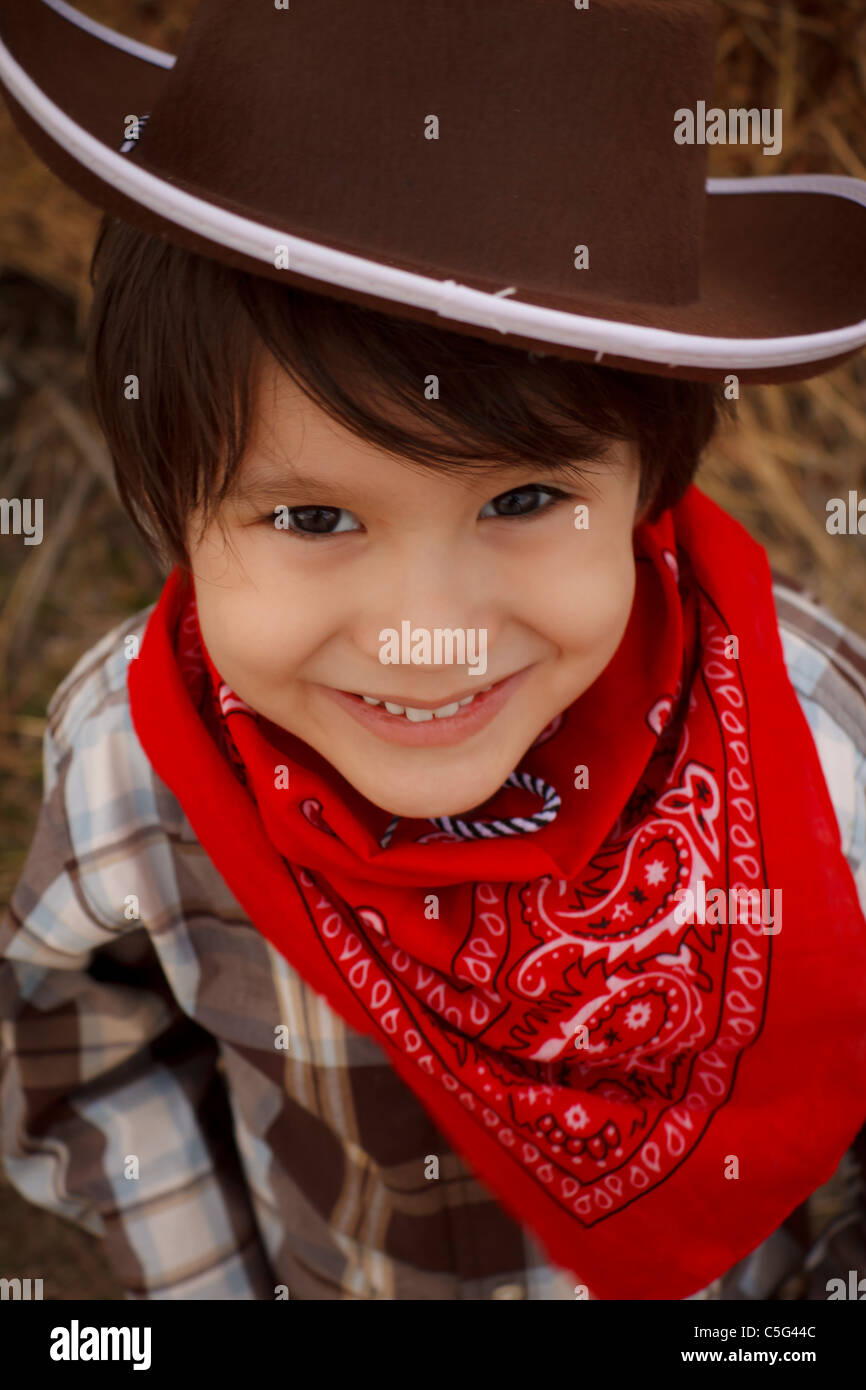 Joven con vestidos con sombrero, camisa a cuadros y un pañuelo rojo  alrededor de su cuello, compartiendo una sonrisa Fotografía de stock - Alamy