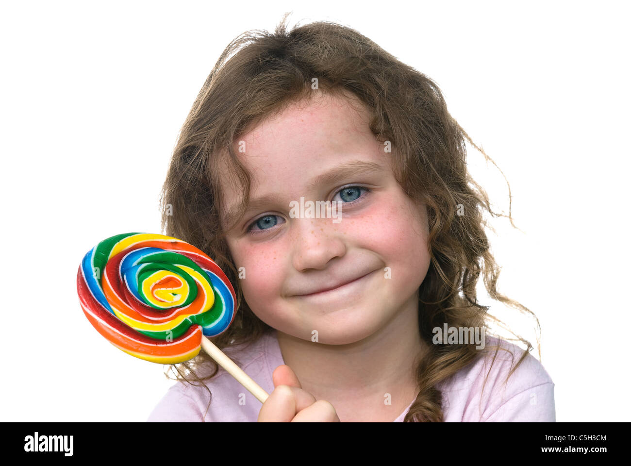 Una niña sonríe mientras disfruta de su candy rueda dentada sucker Foto de stock