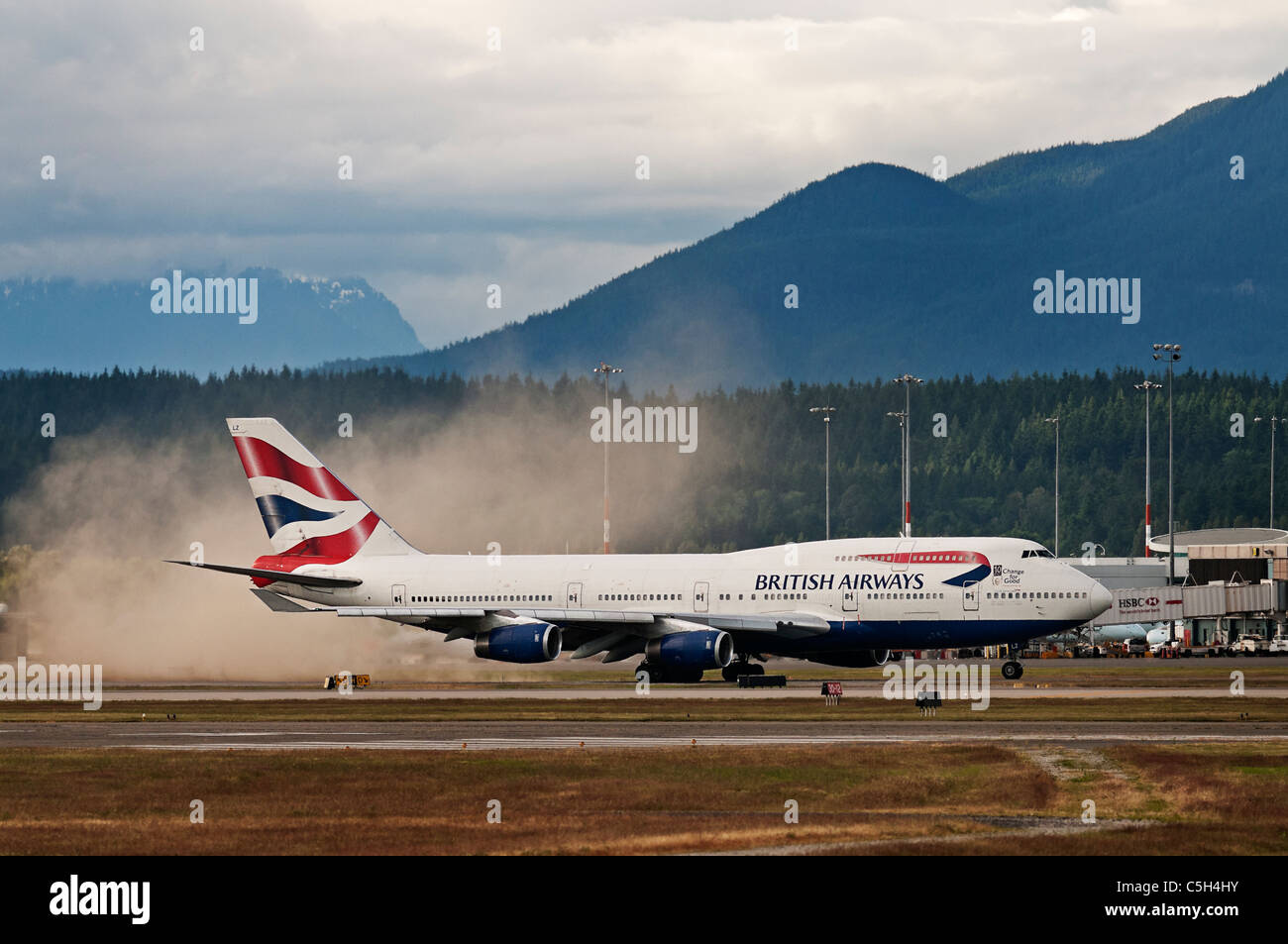 Empuje el motor Jet de un Boeing 747 de British Airways comienza subiendo una pequeña tormenta de polvo como taxis a lo largo del asfalto. Foto de stock