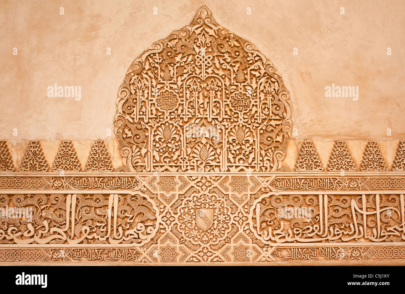 Árabe tallado en piedra en una pared en los palacios nazaríes de la Alhambra de Granada, España. Foto de stock