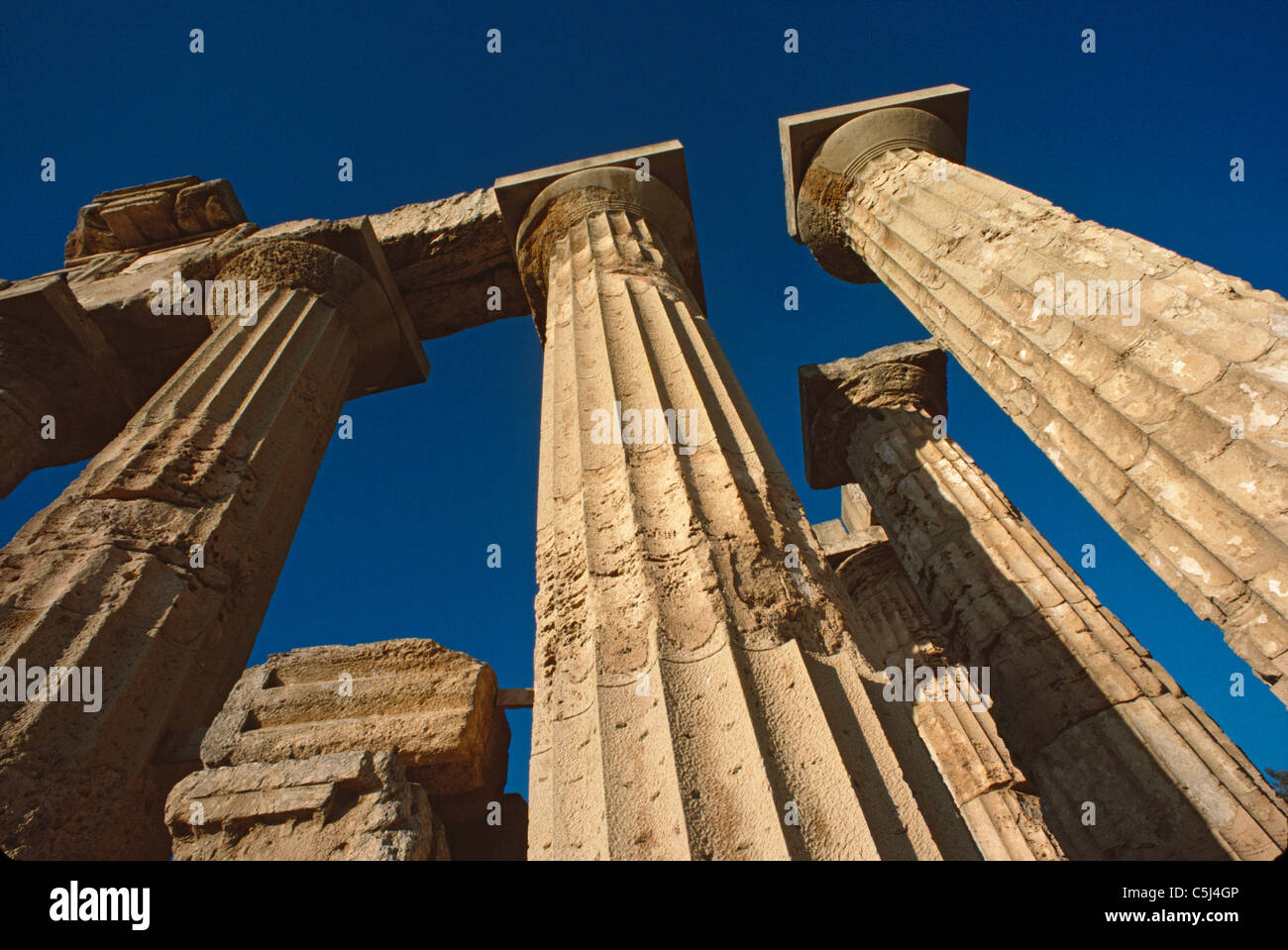 Columnas esbozadas contra el cielo azul en el templo de Aphaia, en la isla de Aegina, Grecia Foto de stock
