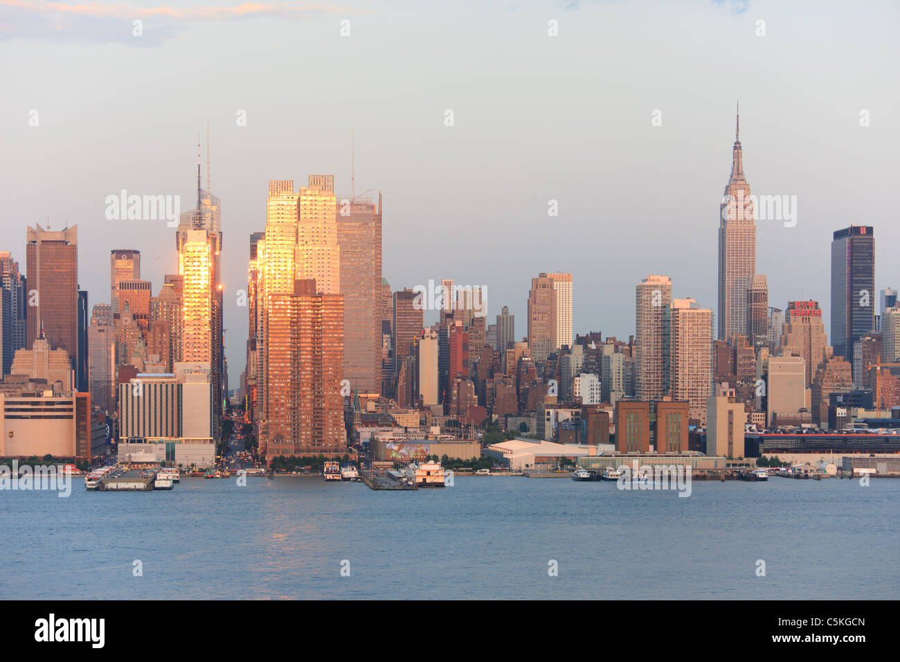 La puesta del sol se refleja en las ventanas de rascacielos de Manhattan en la calle 42 como se ve en el río Hudson desde Nueva Jersey Foto de stock