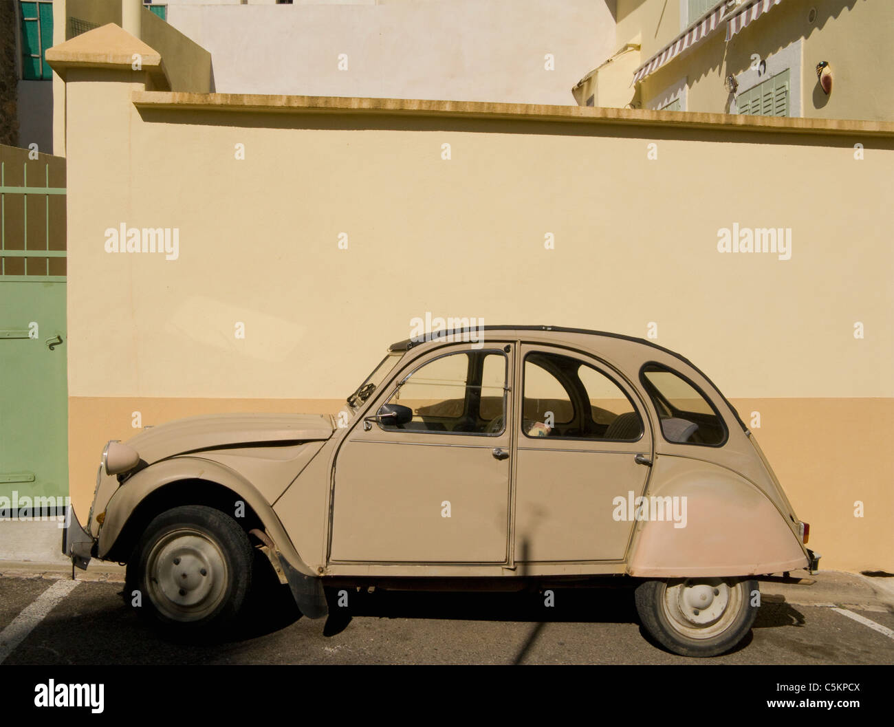 Un viejo beige Citron Deux Chevaux coche aparcado por una coincidencia de pared, Servian, Francia Foto de stock