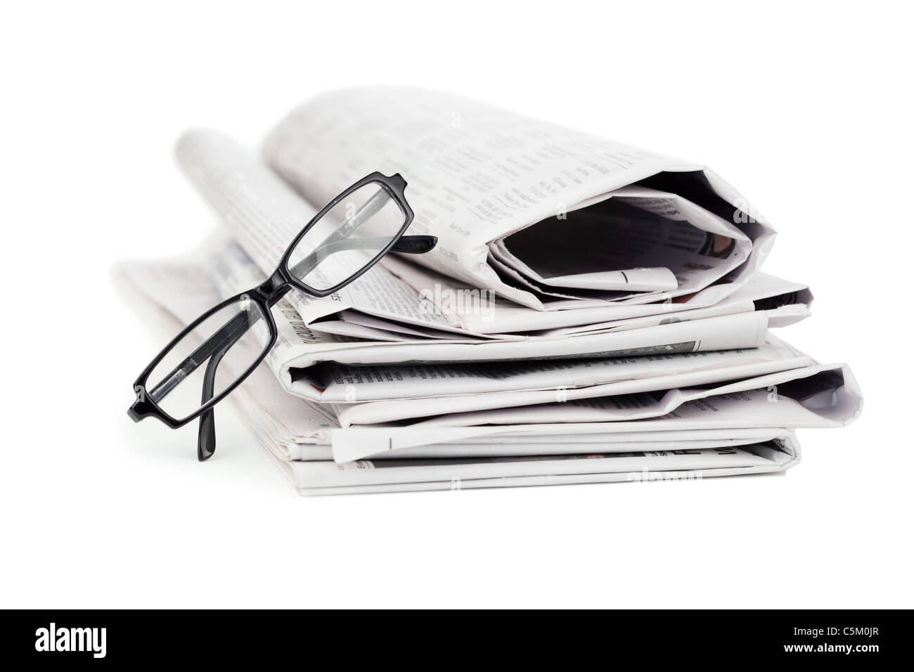 Una pila de periódicos y un par de gafas de lectura Foto de stock