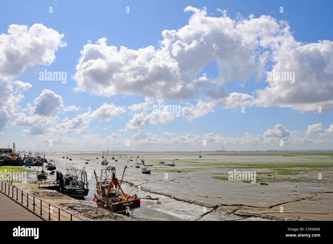 Thames Estuary paisaje en marea baja, botes y pisos de lodo en Leigh, sobre el Mar de la costa de Essex Inglaterra con Kent costa distante horizonte con nubes en el big sky Foto de stock