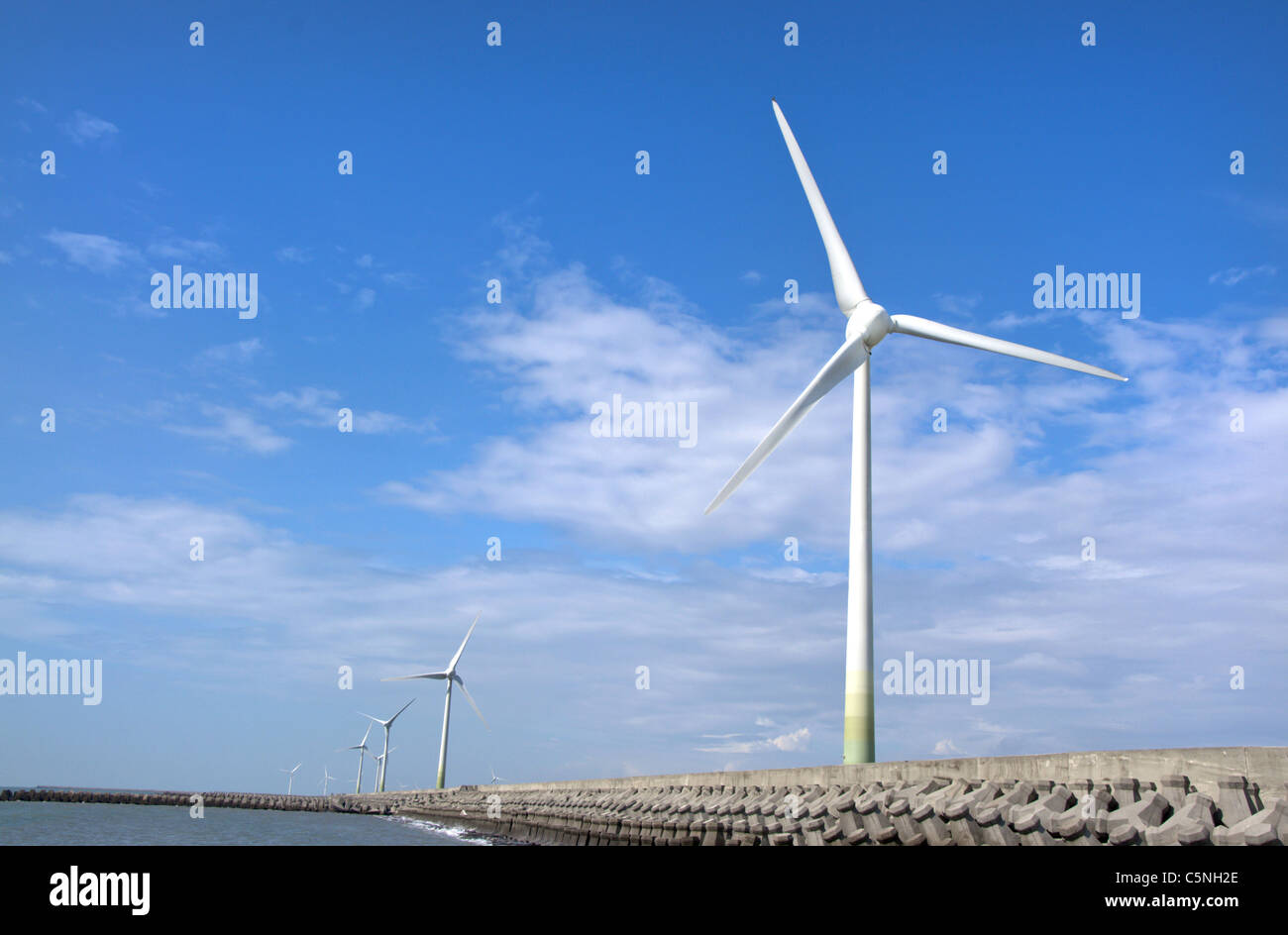 Grupo de energía eólica en la orilla Foto de stock