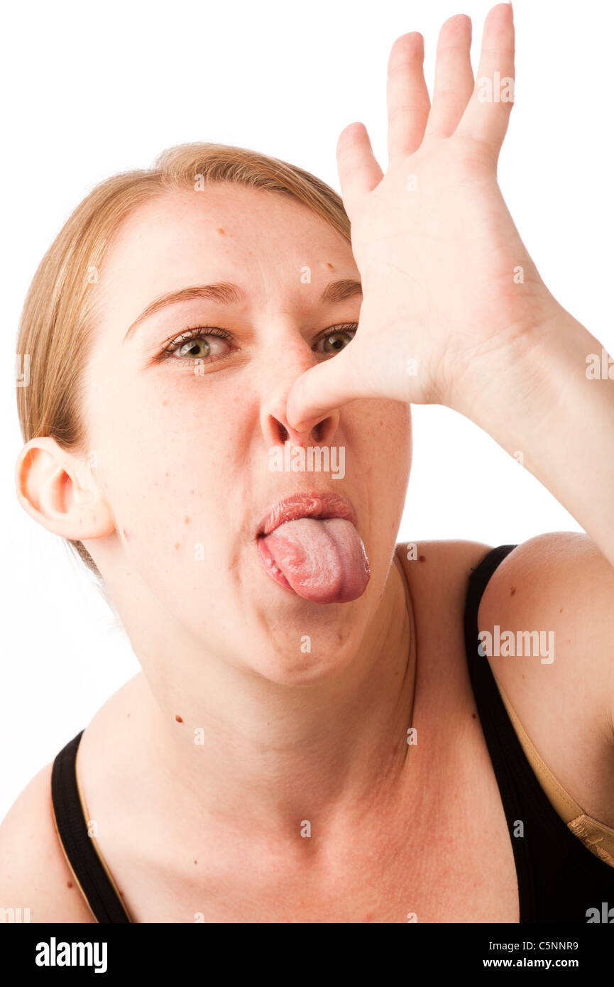 Una joven mujer caucásica haciendo un gesto insultante, thumbing su mano en su nariz Foto de stock