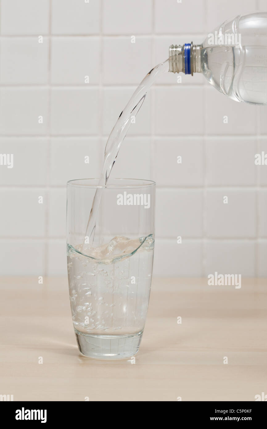Verter en el vaso de agua mineral Foto de stock
