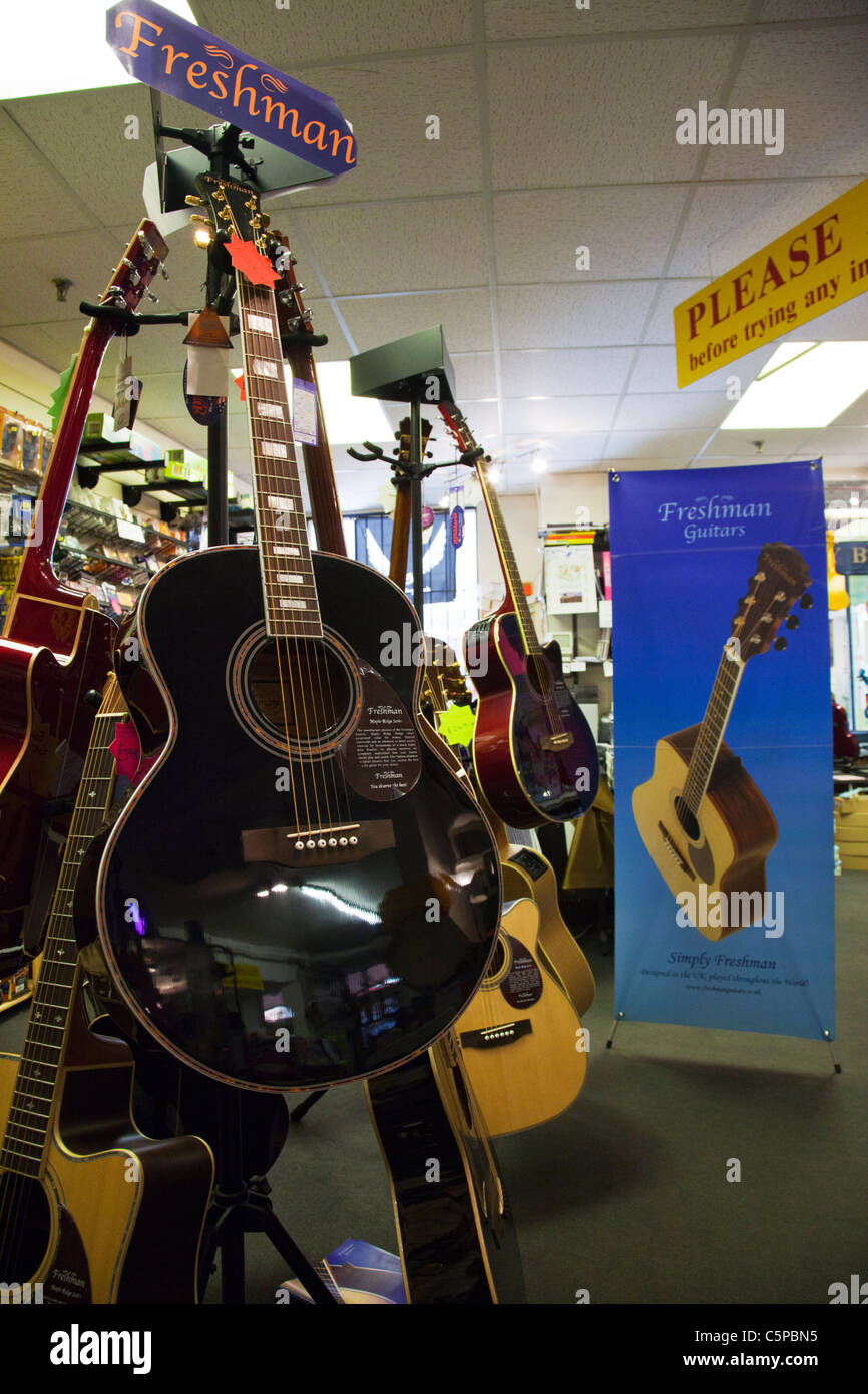 Soporte guitarra novato en una tienda de música mostrando guitarras