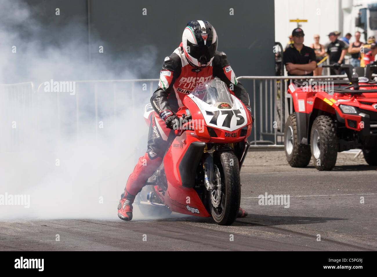 Ducati 749R moto realizando un neumático de carreras Burnout fumar antes en la franja de arrastre Foto de stock