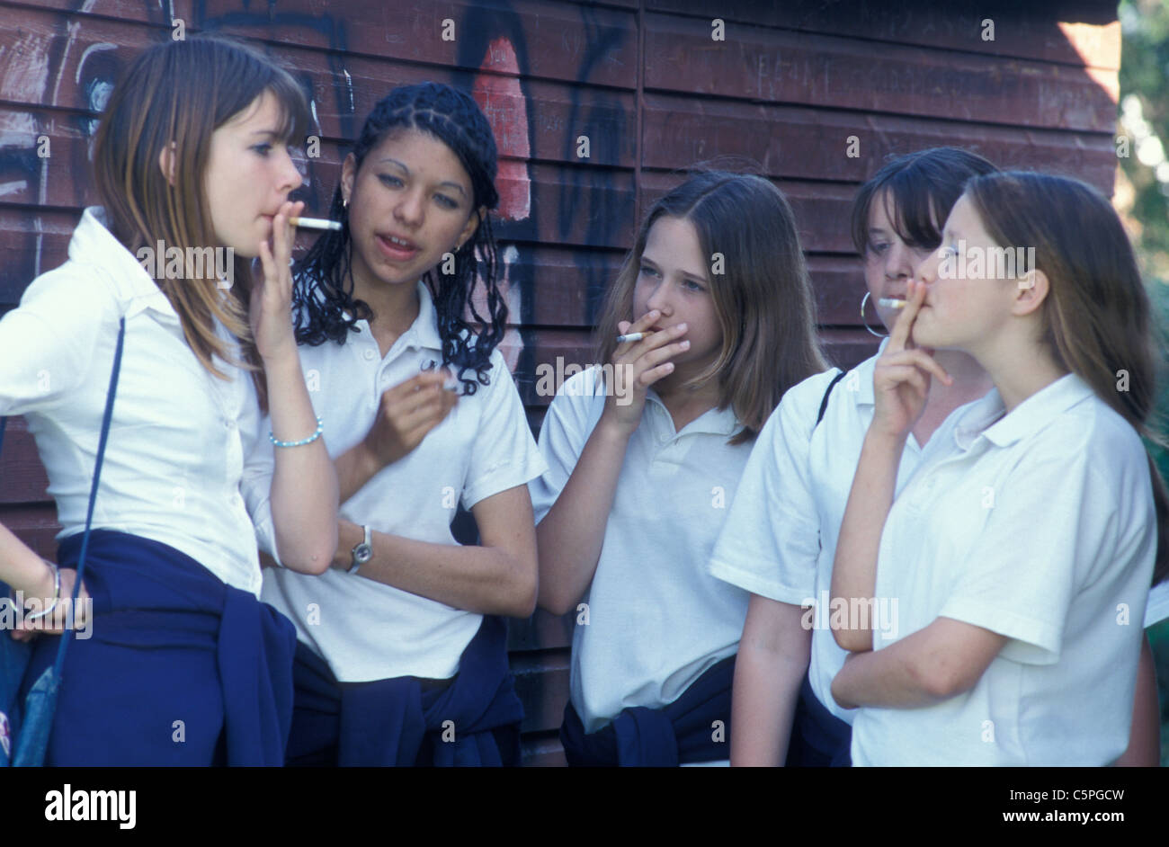 Cinco Niñas De Escuela Secundaria Fumando Detrás De Arrojar Fotografía De Stock Alamy