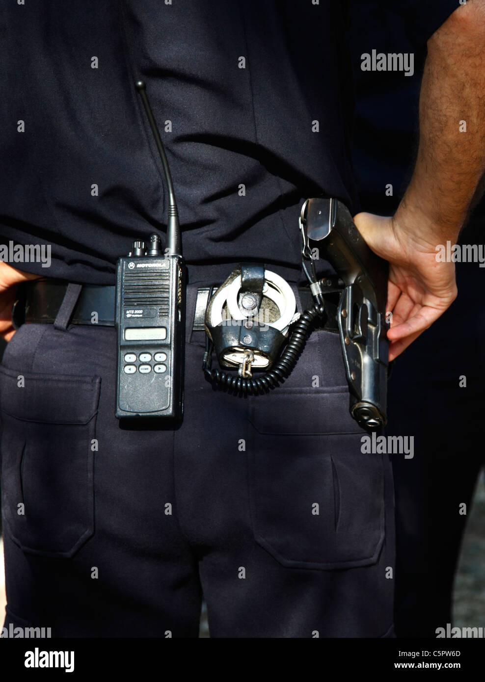 Vista trasera de un policía israelí con un par de esposas de una pistola y un transmisor de radio portátil en su cinturón Foto de stock