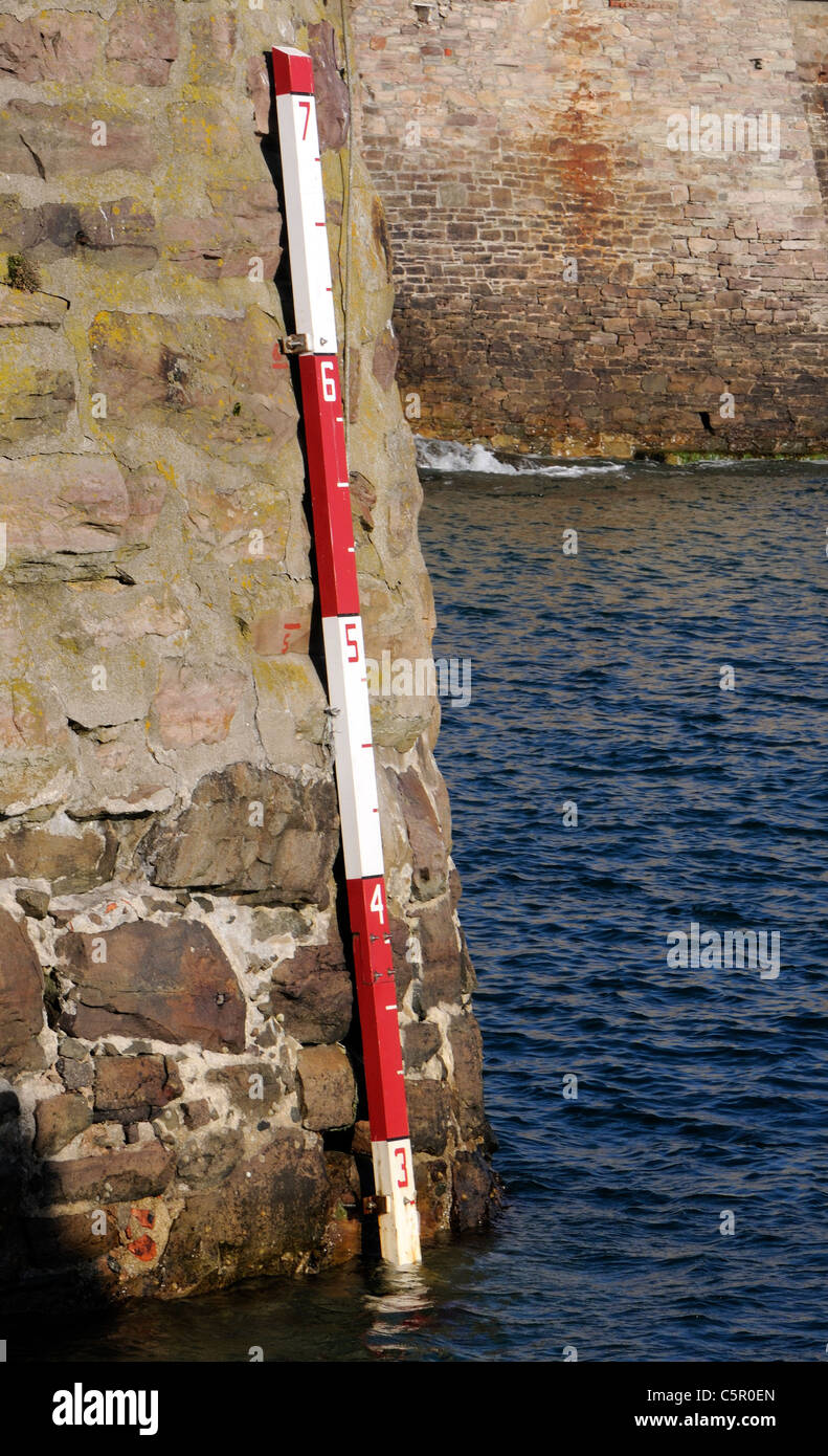 Medir la profundidad del agua en la pared de Braye Harbour. Alderney, Islas del Canal, REINO UNIDO Foto de stock
