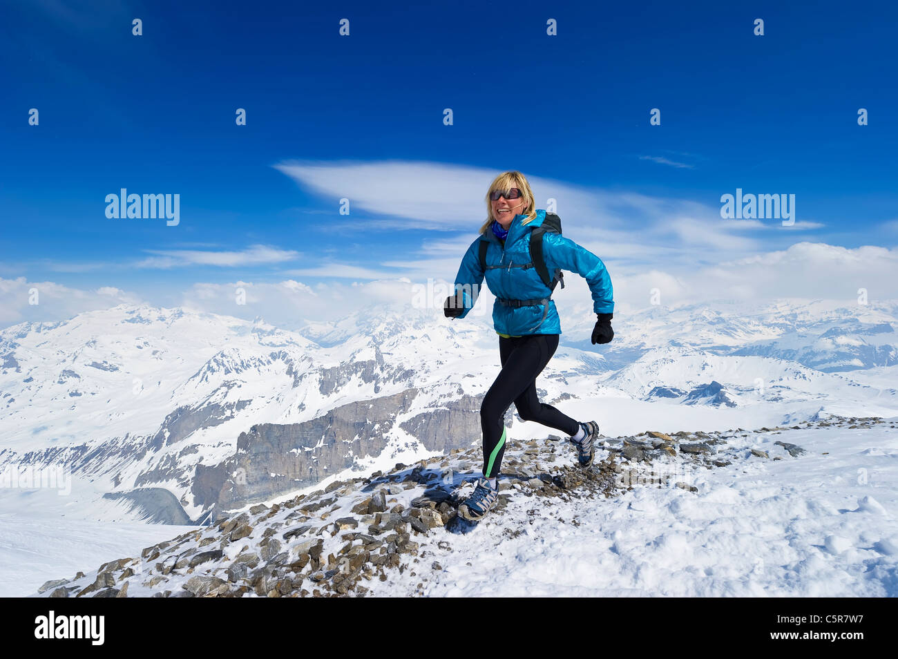 La mujer disfruta de una carrera a través de una cordillera Alpes nevados. Foto de stock