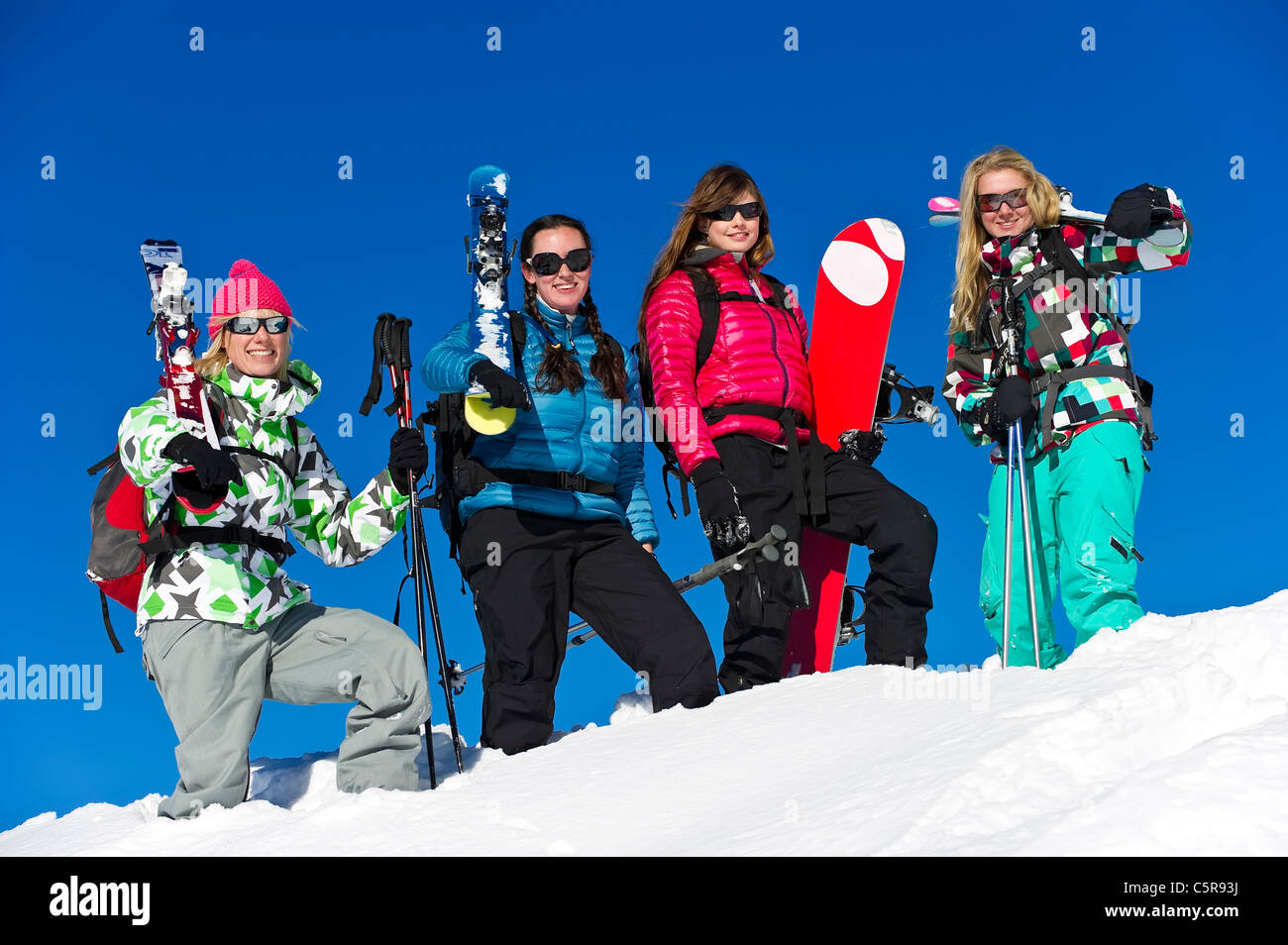 Cuatro amigos en una vacaciones de esquí y snowboard para divertirse. Foto de stock