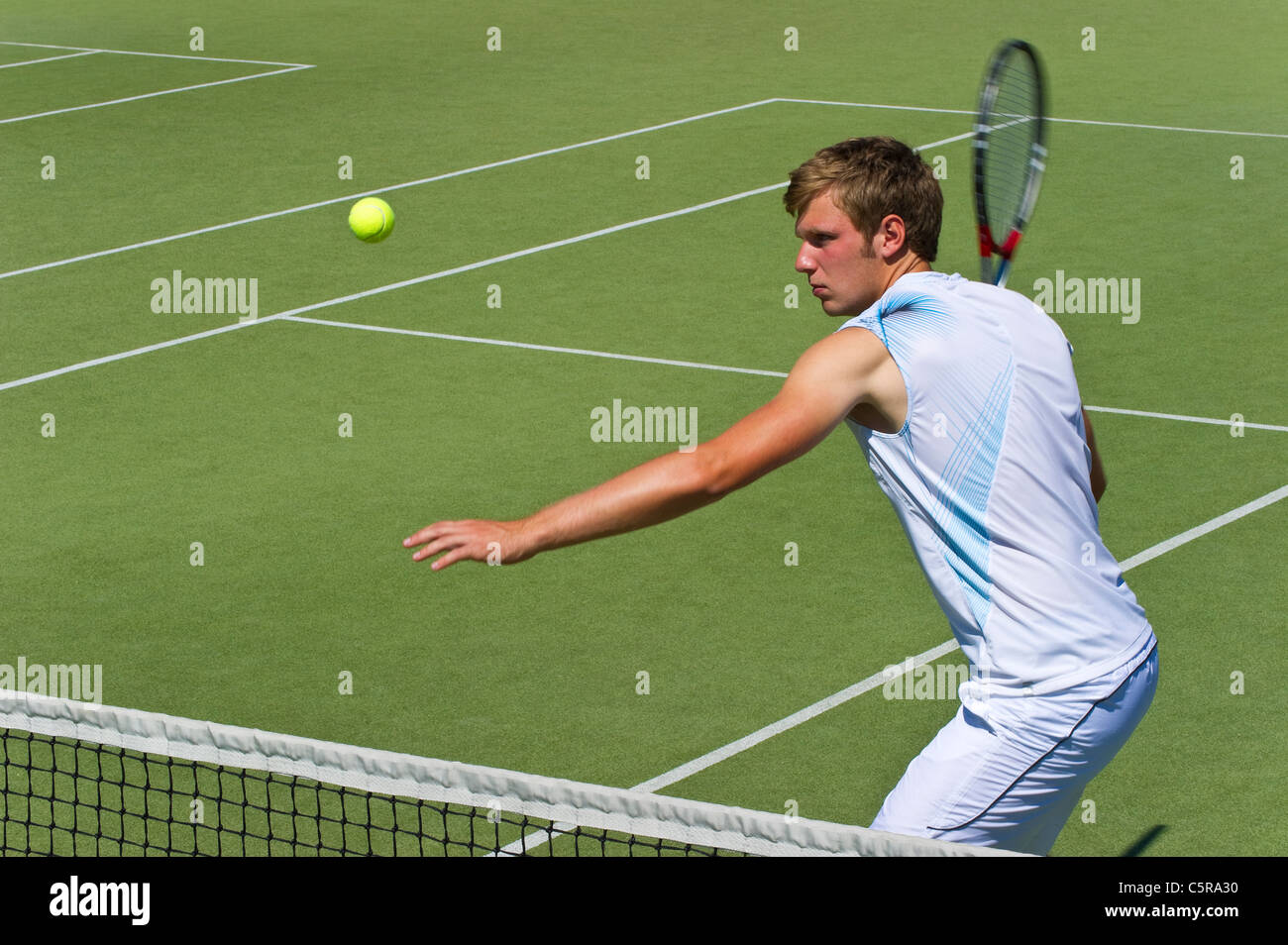 Un jugador de tenis centrado sobre la bola. Foto de stock