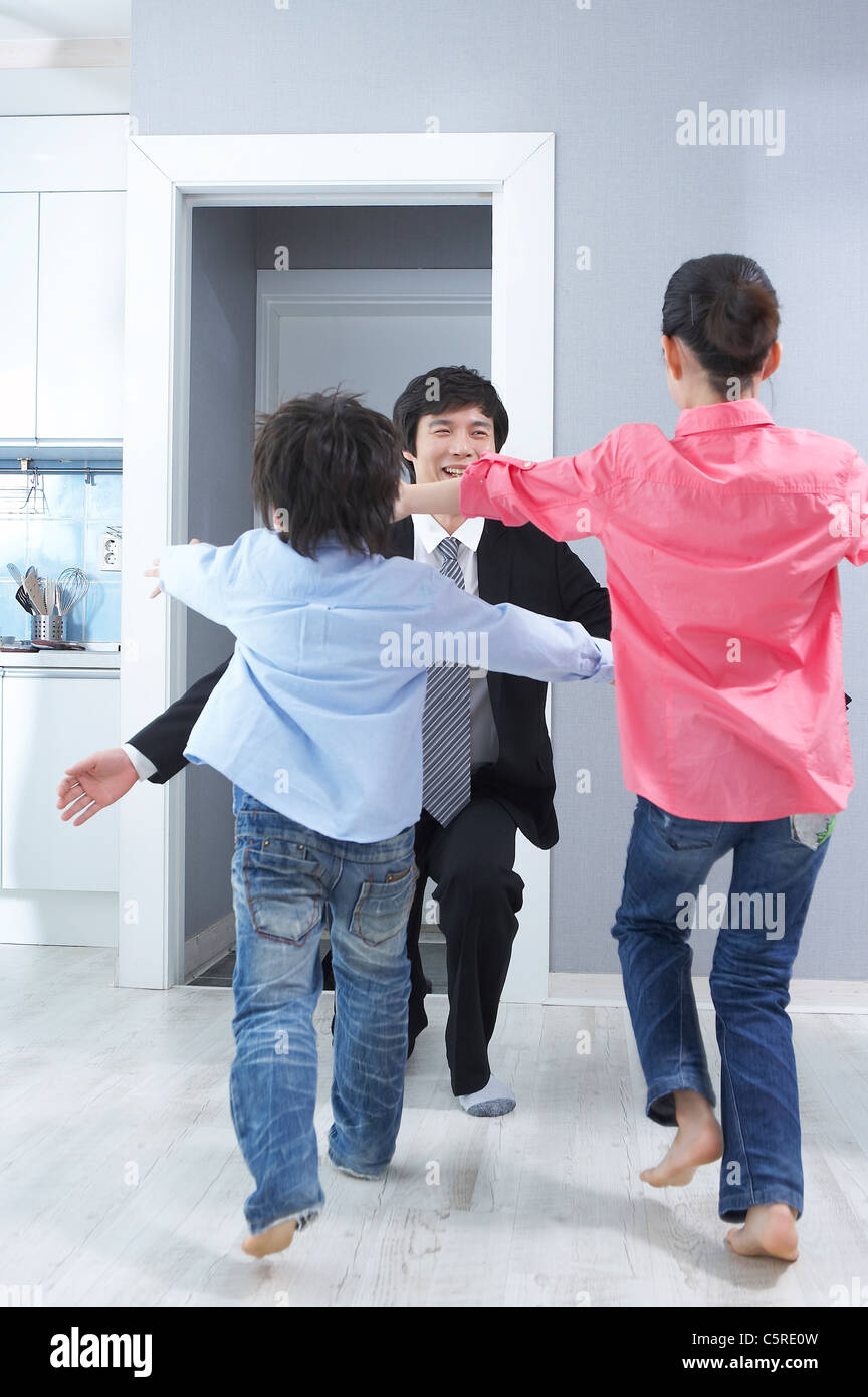 Dos niños saludando a su padre regresando a casa Fotografía de stock - Alamy