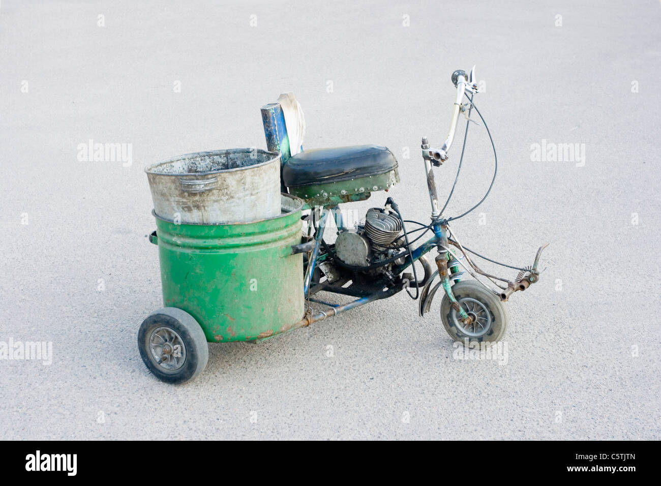 Scooter de tres ruedas caseras de diseño sencillo. Contra el telón de fondo del asfalto Foto de stock