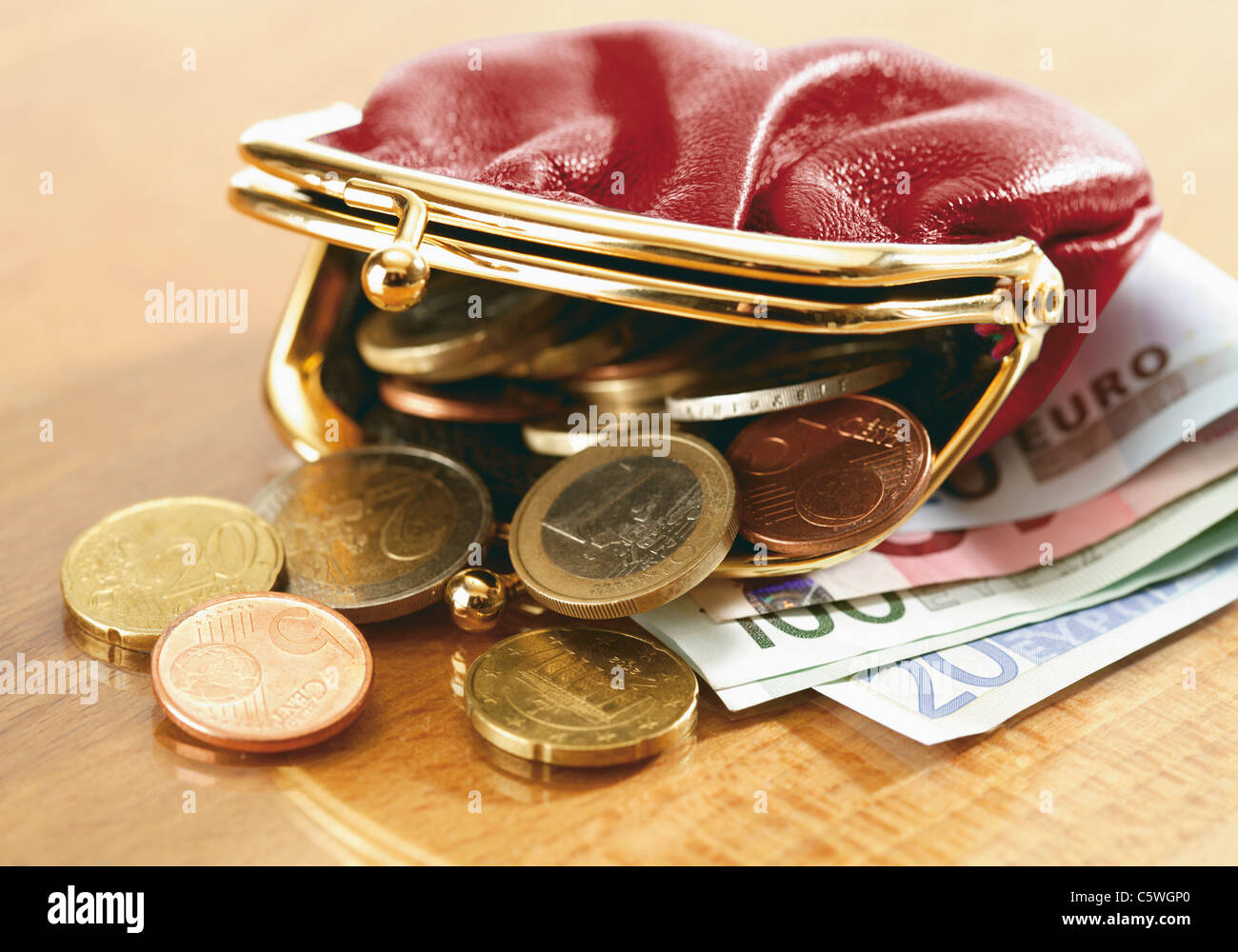 Cierre monedero derramando monedas Fotografía de stock - Alamy